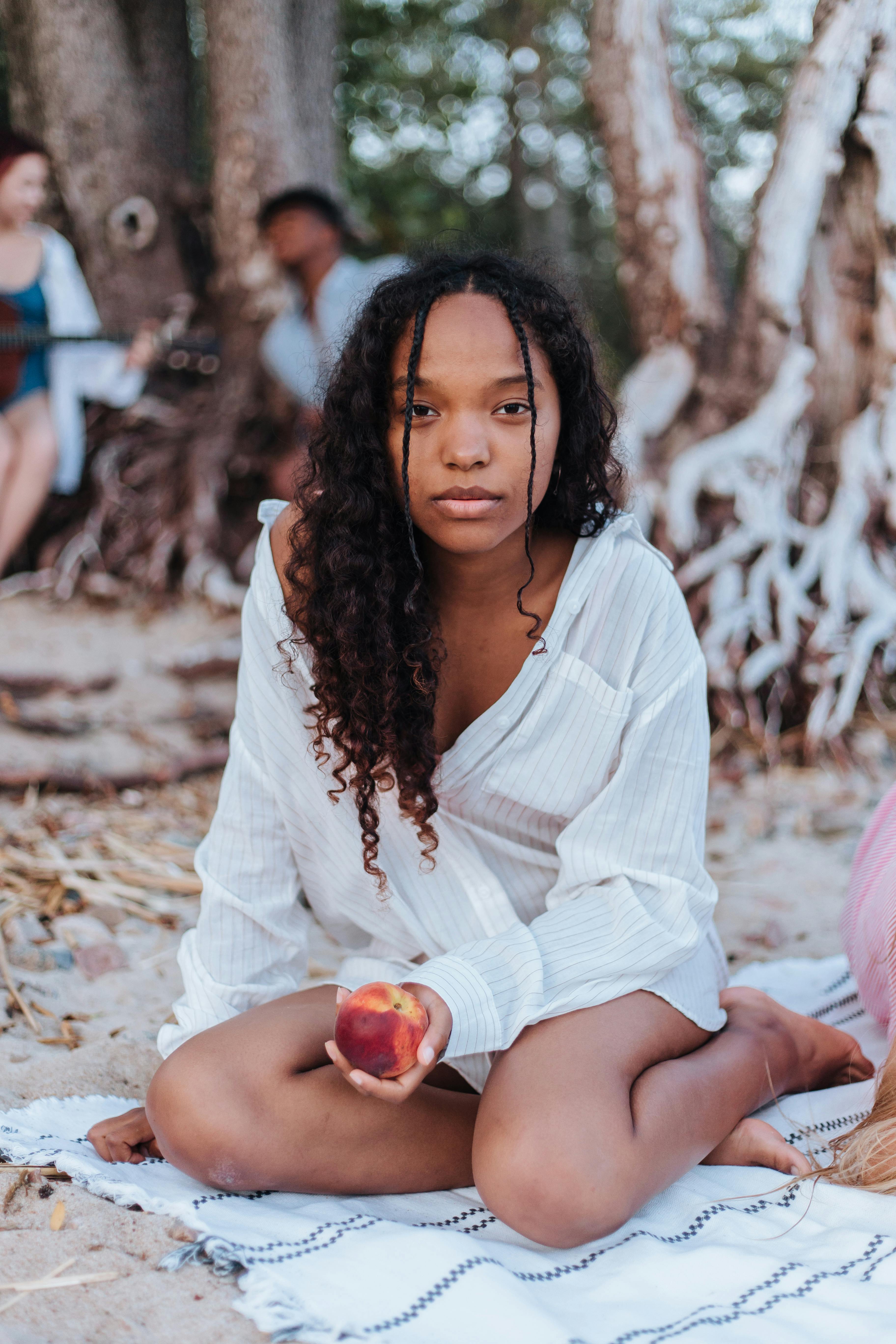 girl on the blanket holding a peach