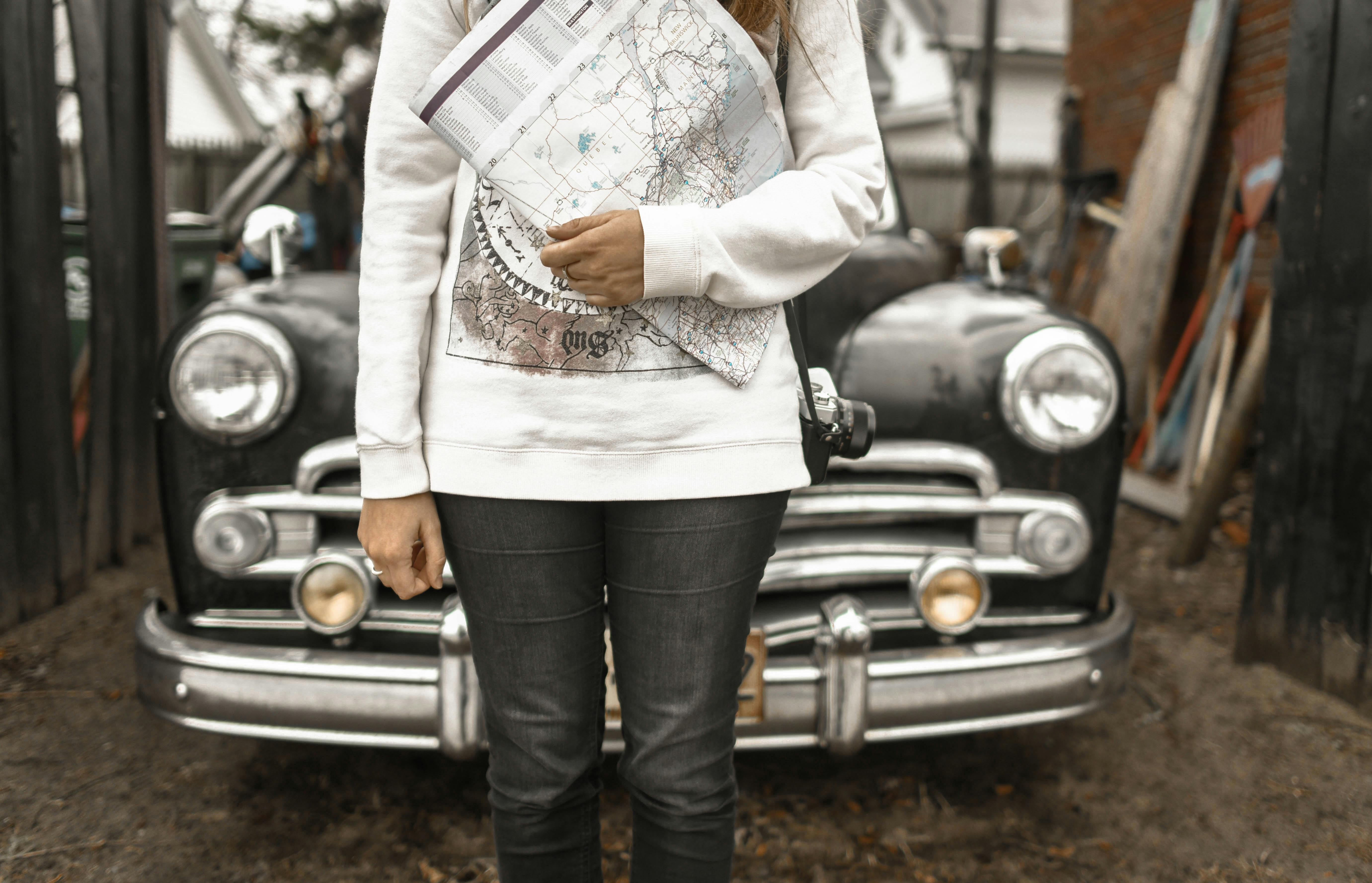 person holding map with car at the back