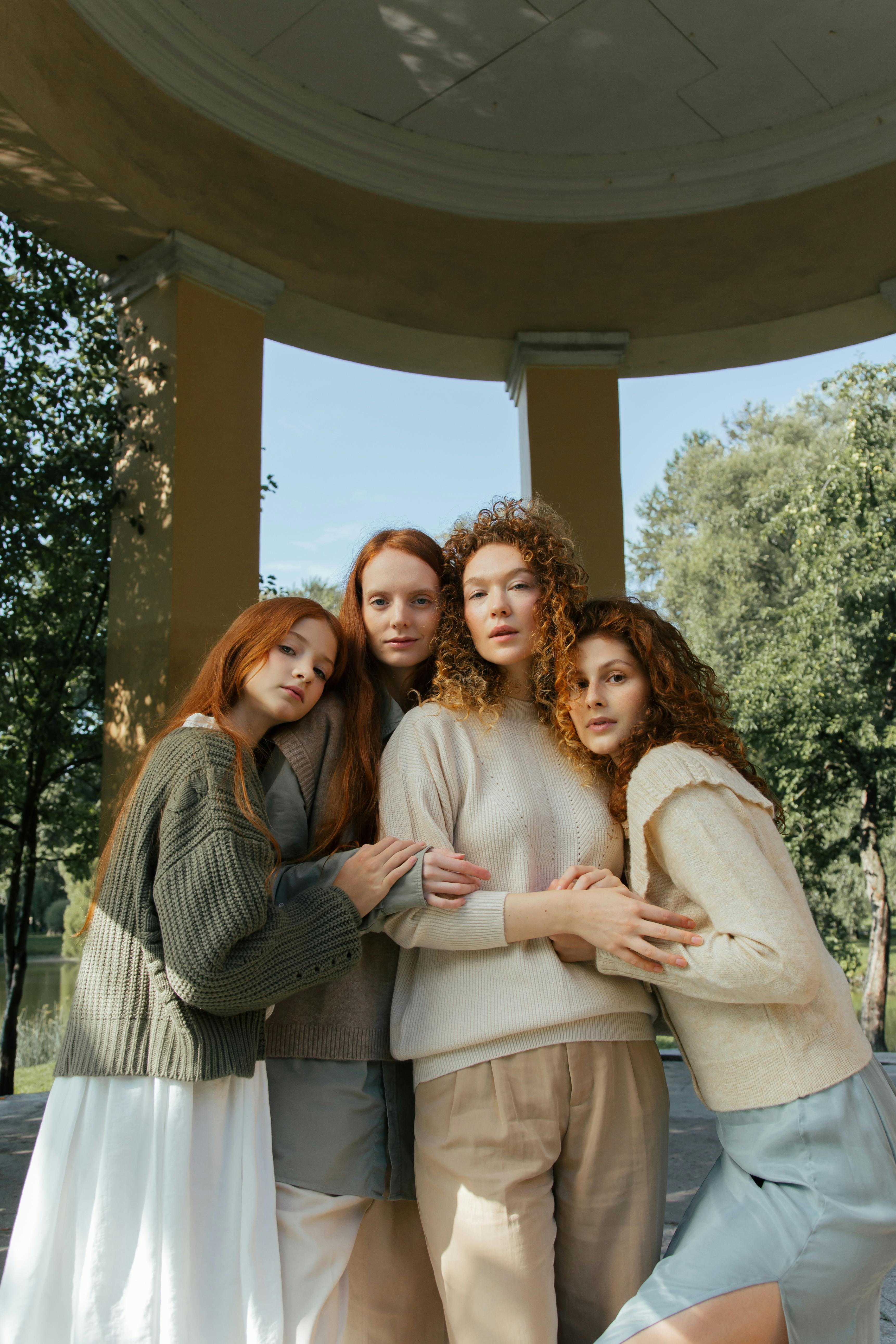 portrait of four female friends hugging in park