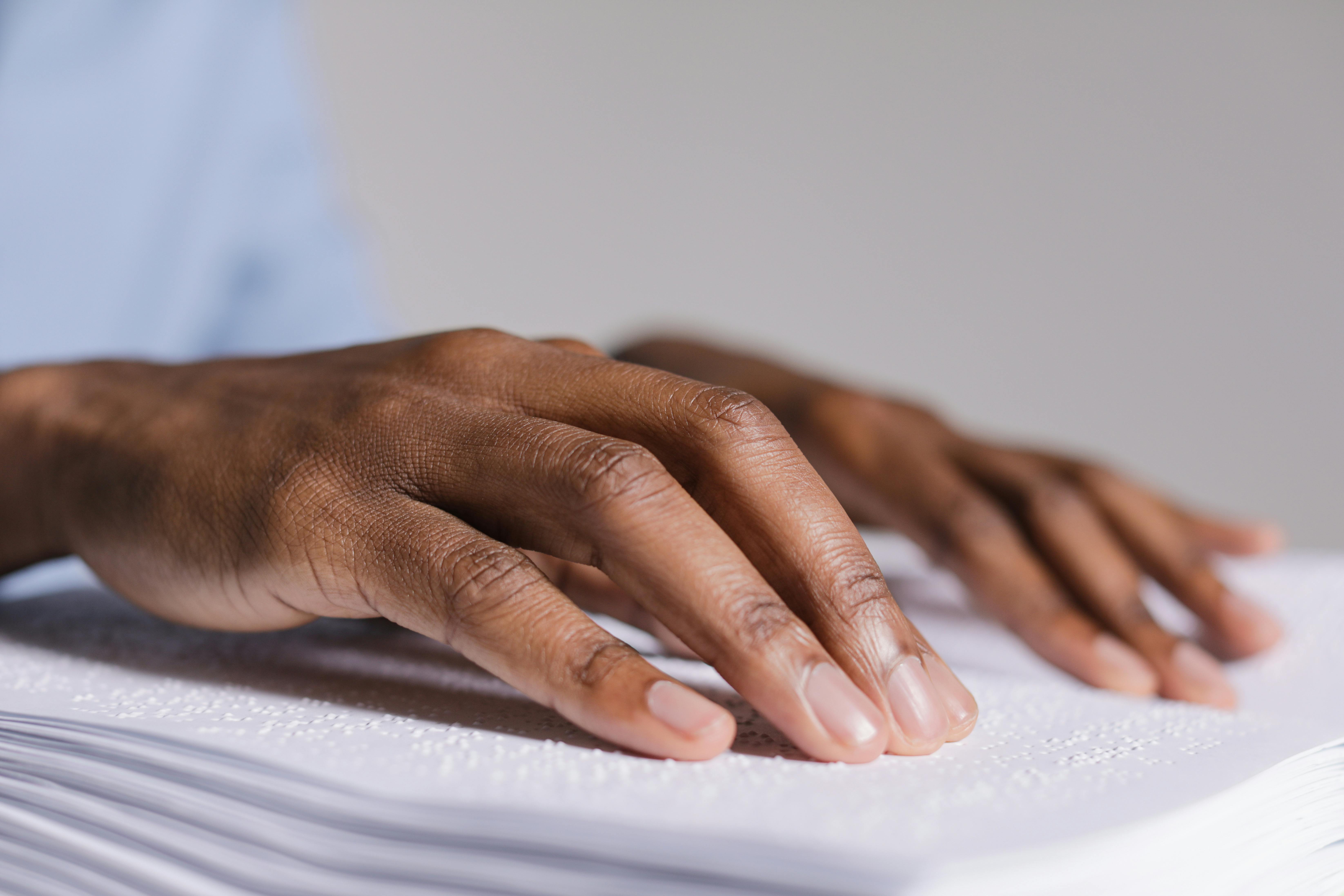 hands touching a braille book