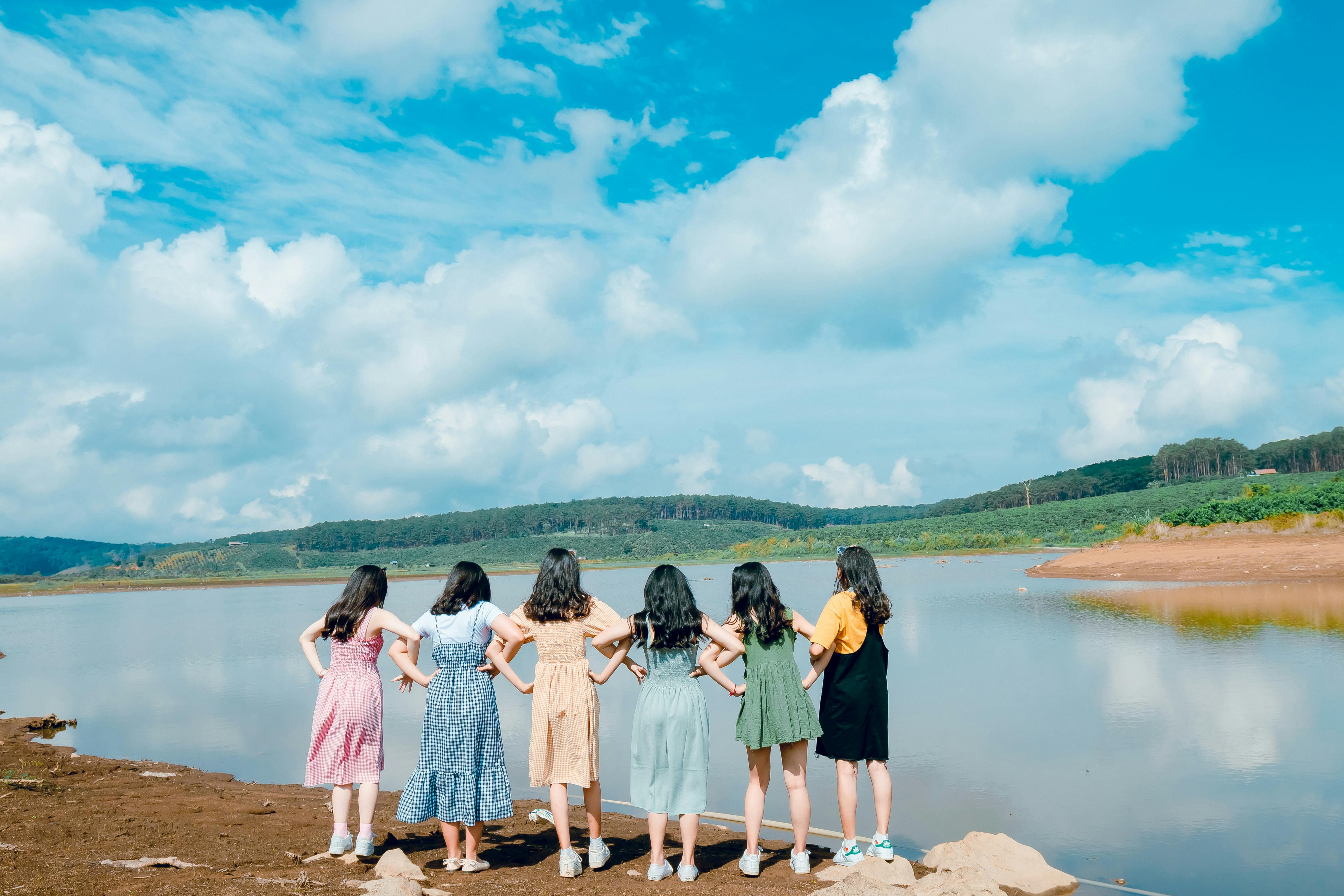 six girl s standing in front of lake