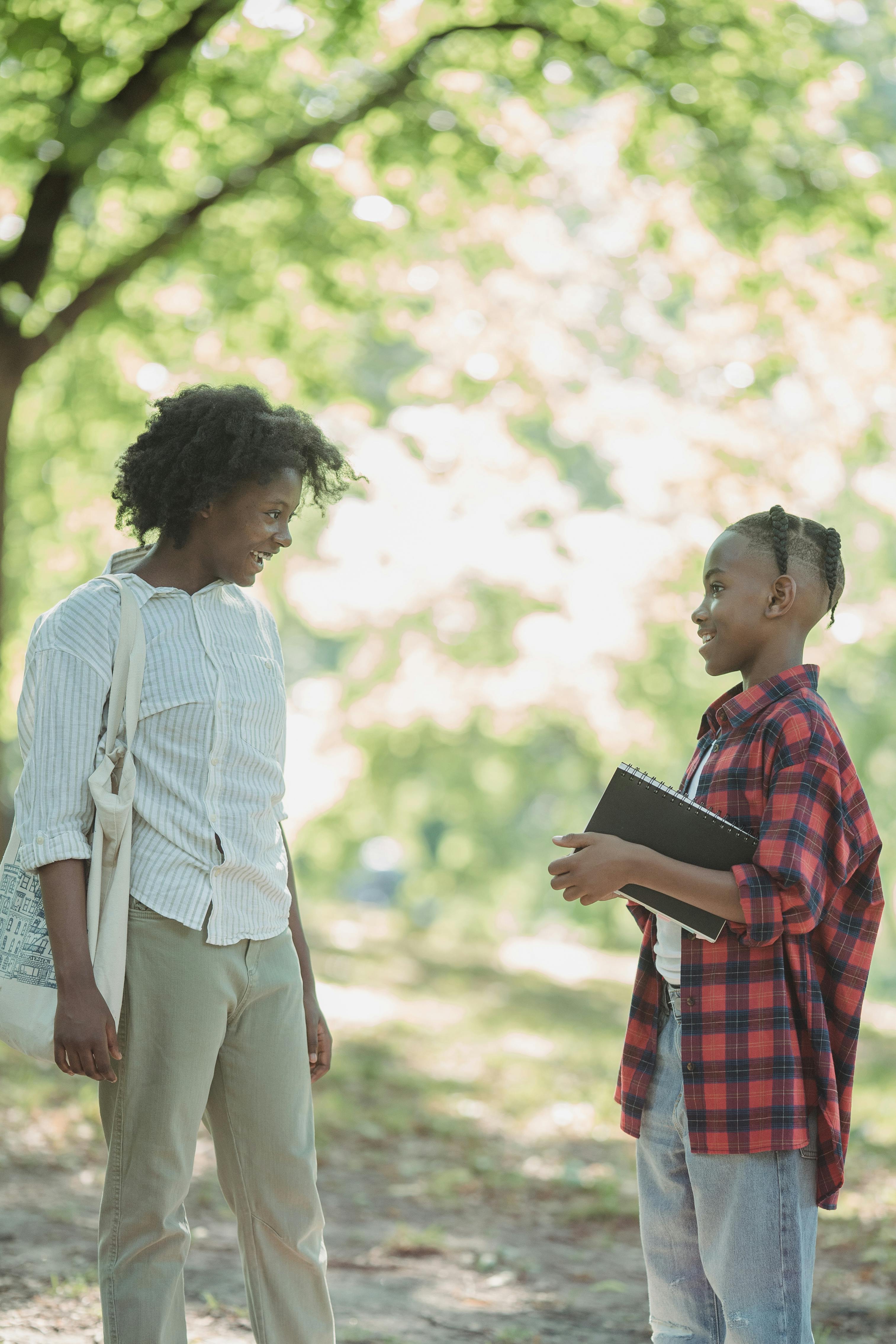 woman and a young boy talking in a park and smiling