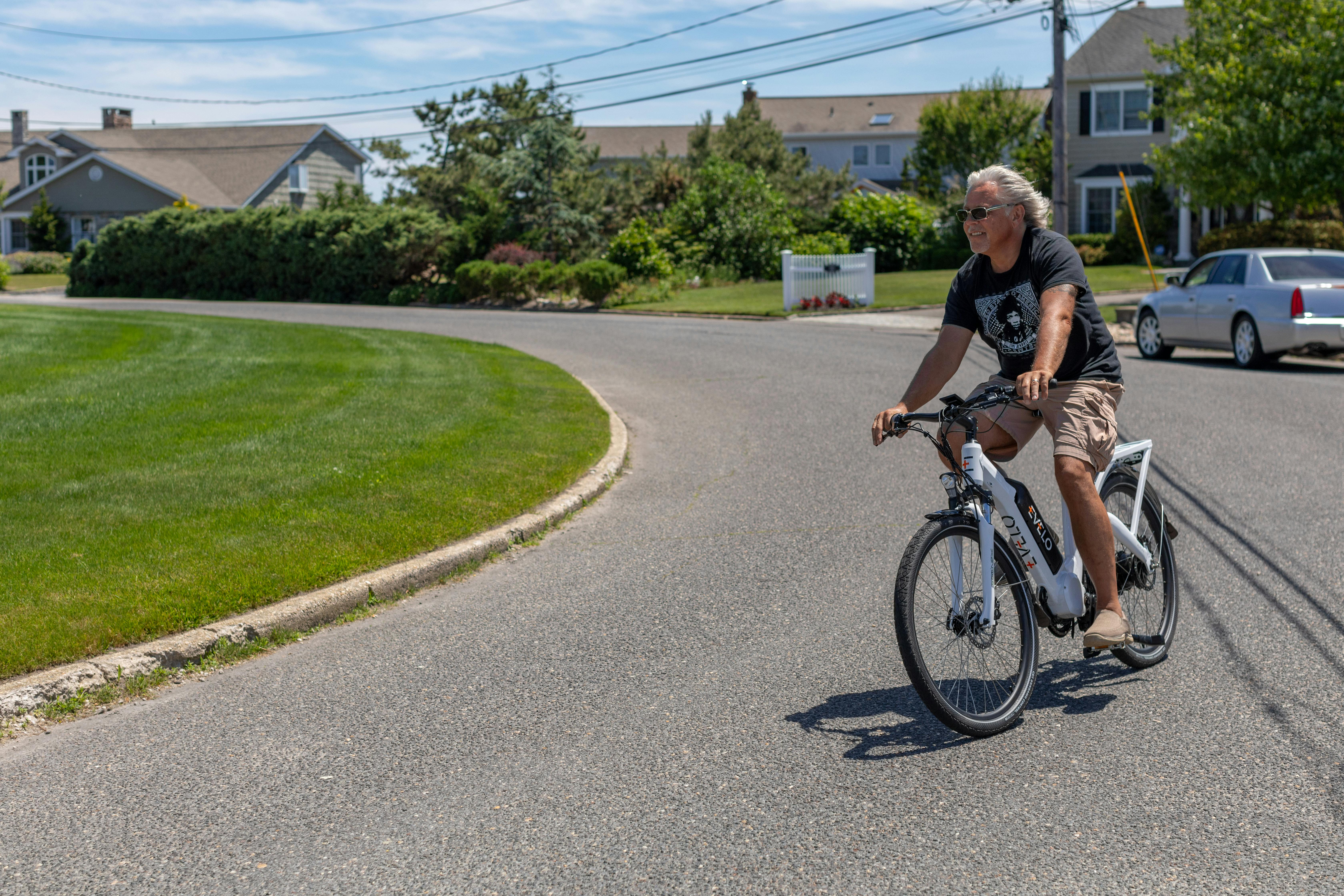 a man riding a bike on a road with a car