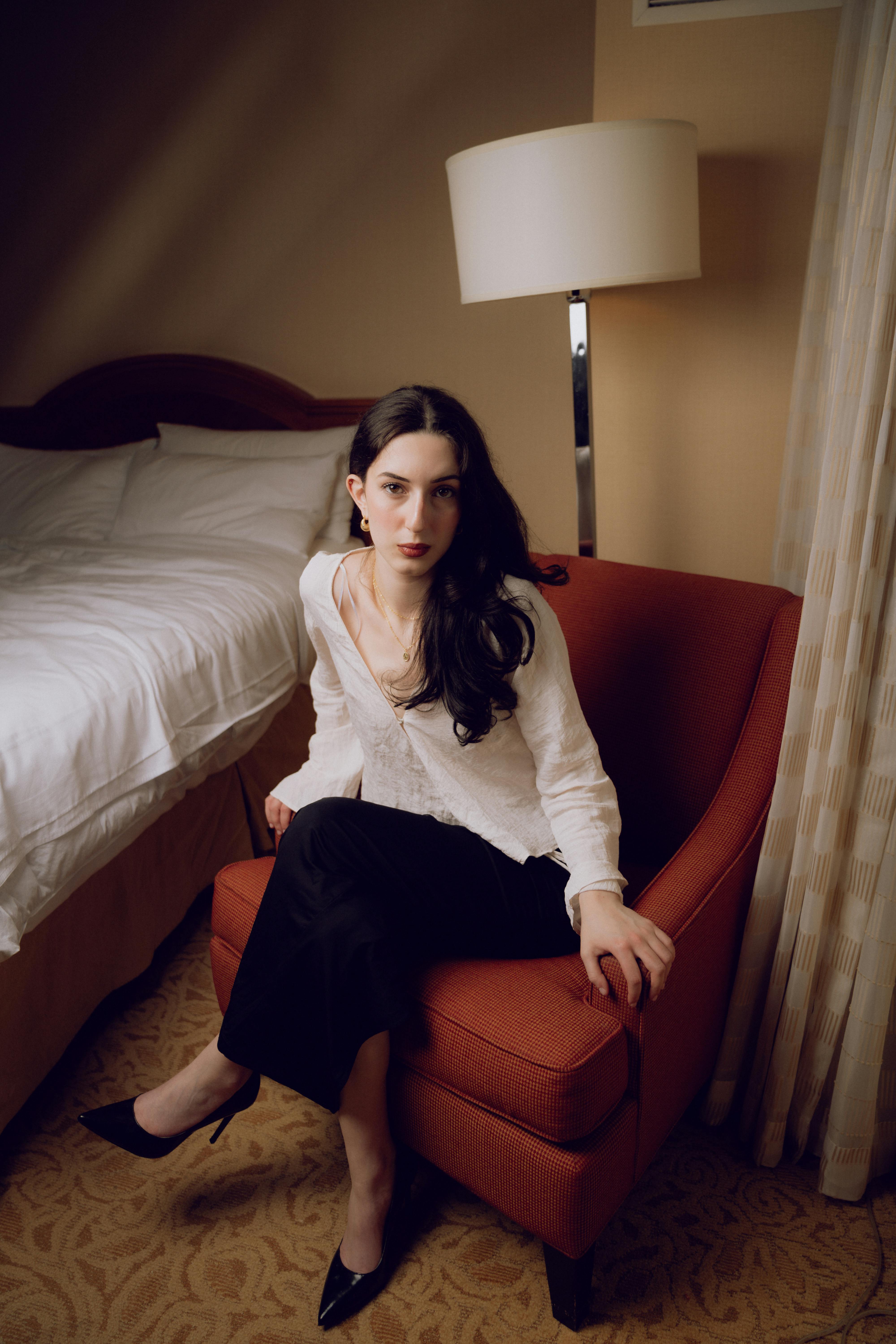 a woman sitting in a chair in a hotel room