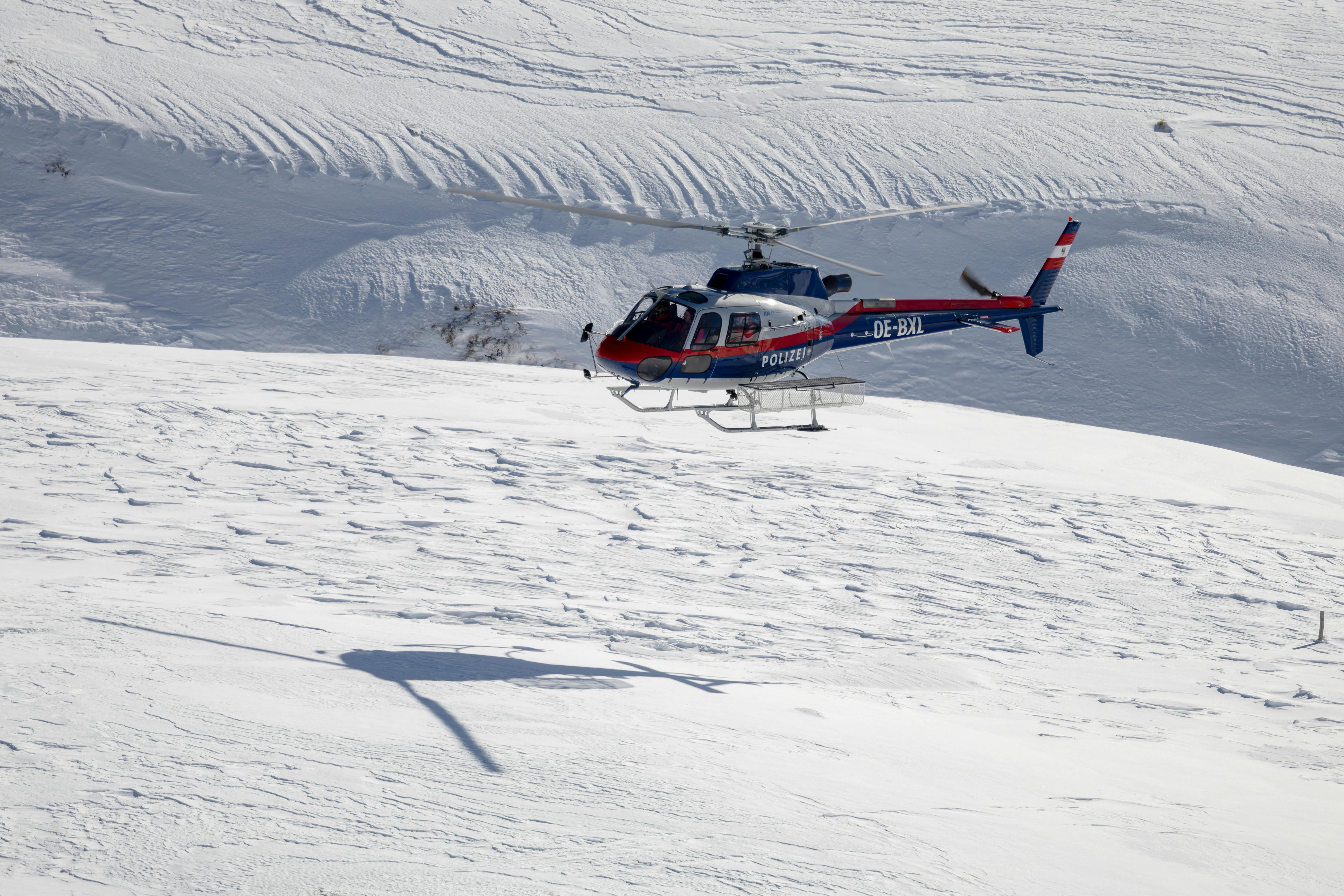 helicopter flying in a mountain valley covered with snow