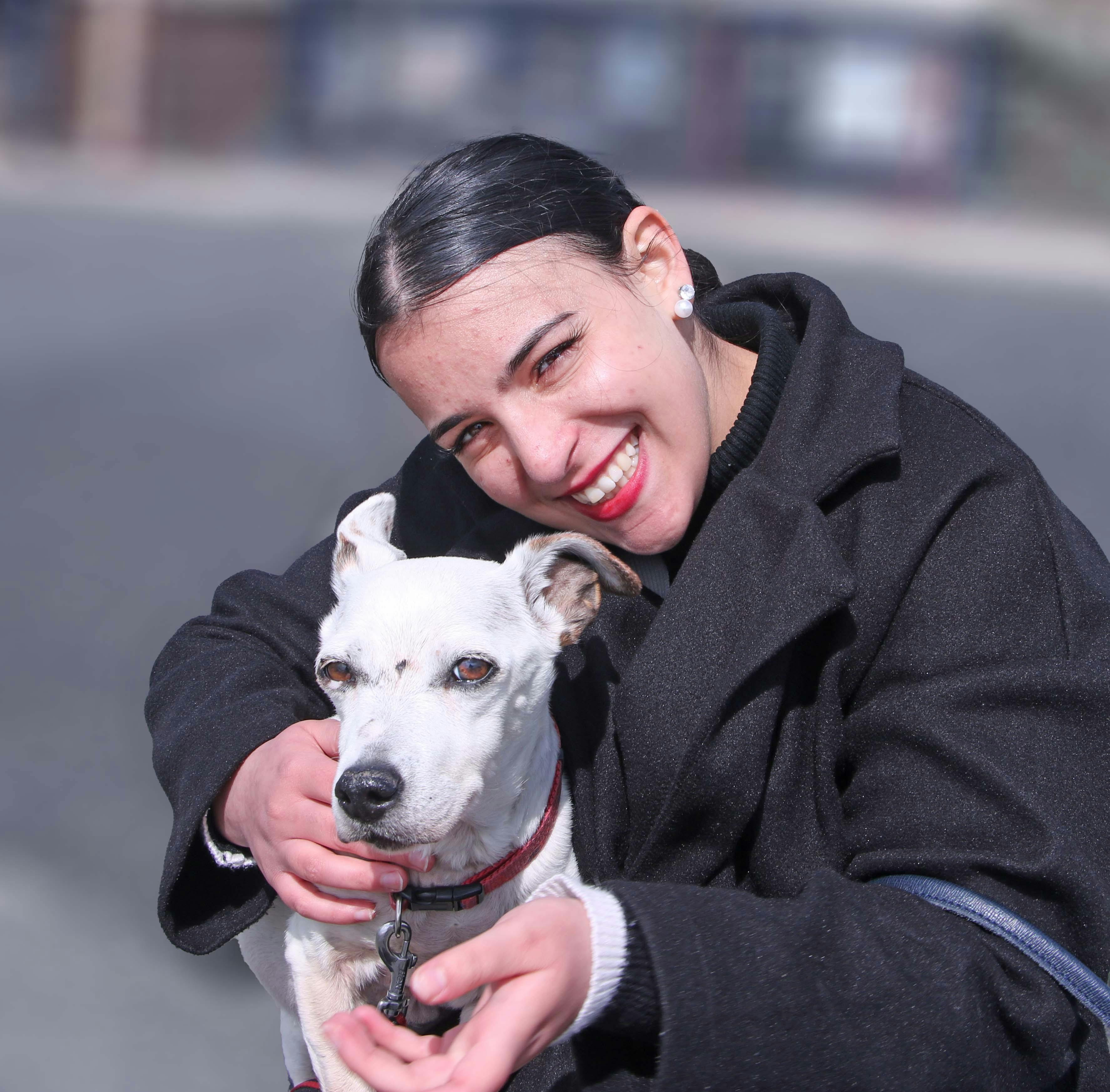 portrait of a smiling woman with white dog