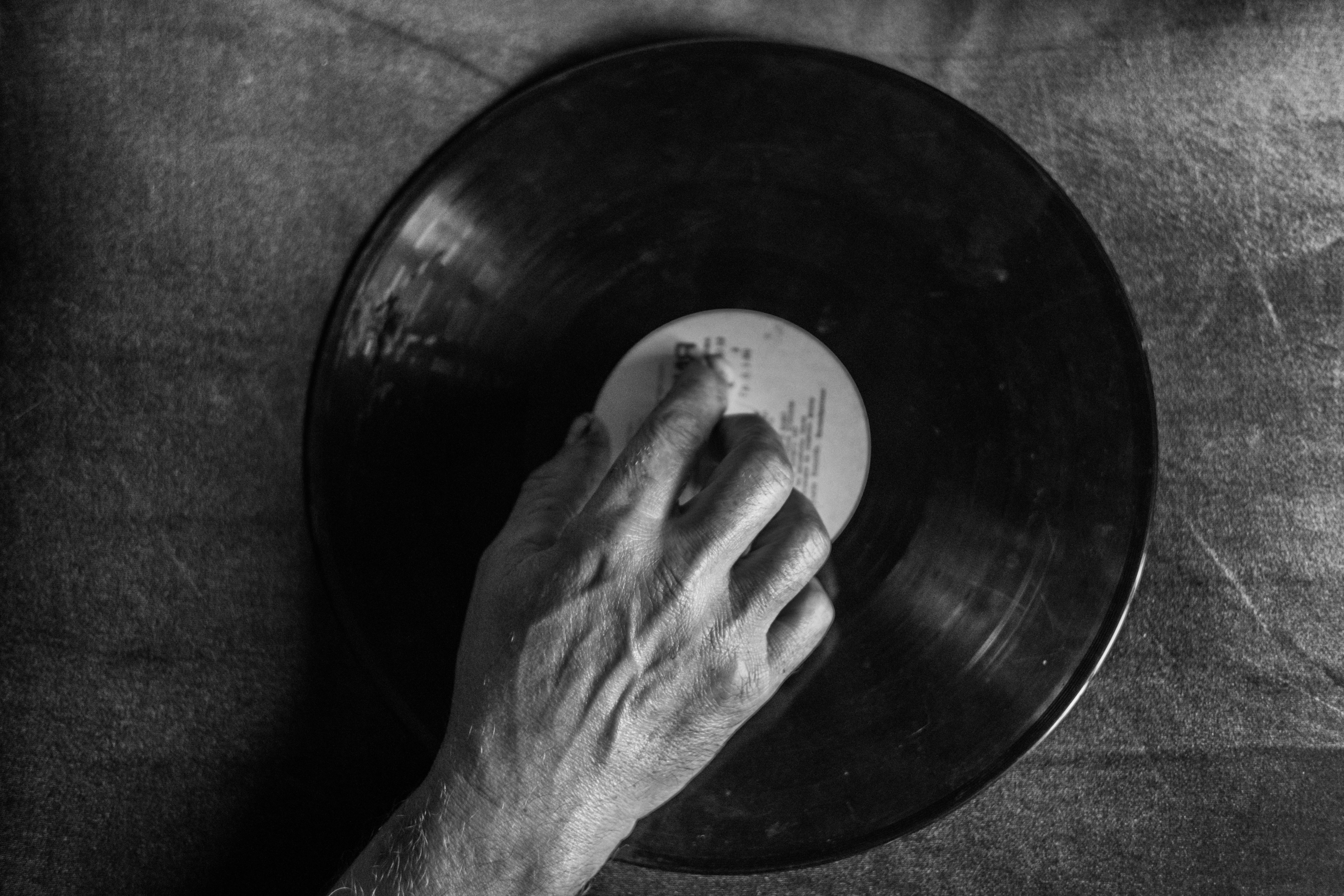 a person s hand holding a record on a black and white table