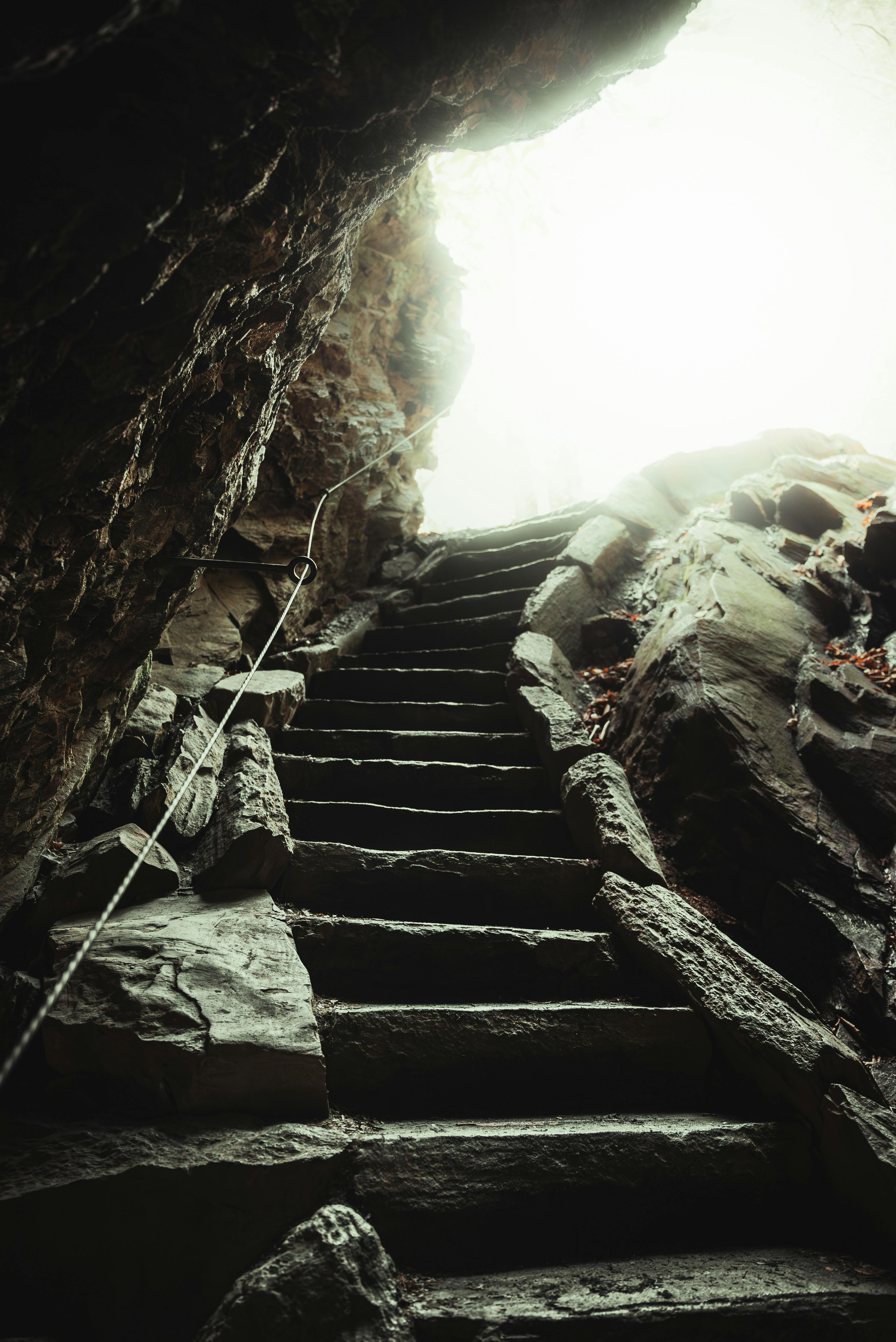 mysterious stairway emerging from cave into light