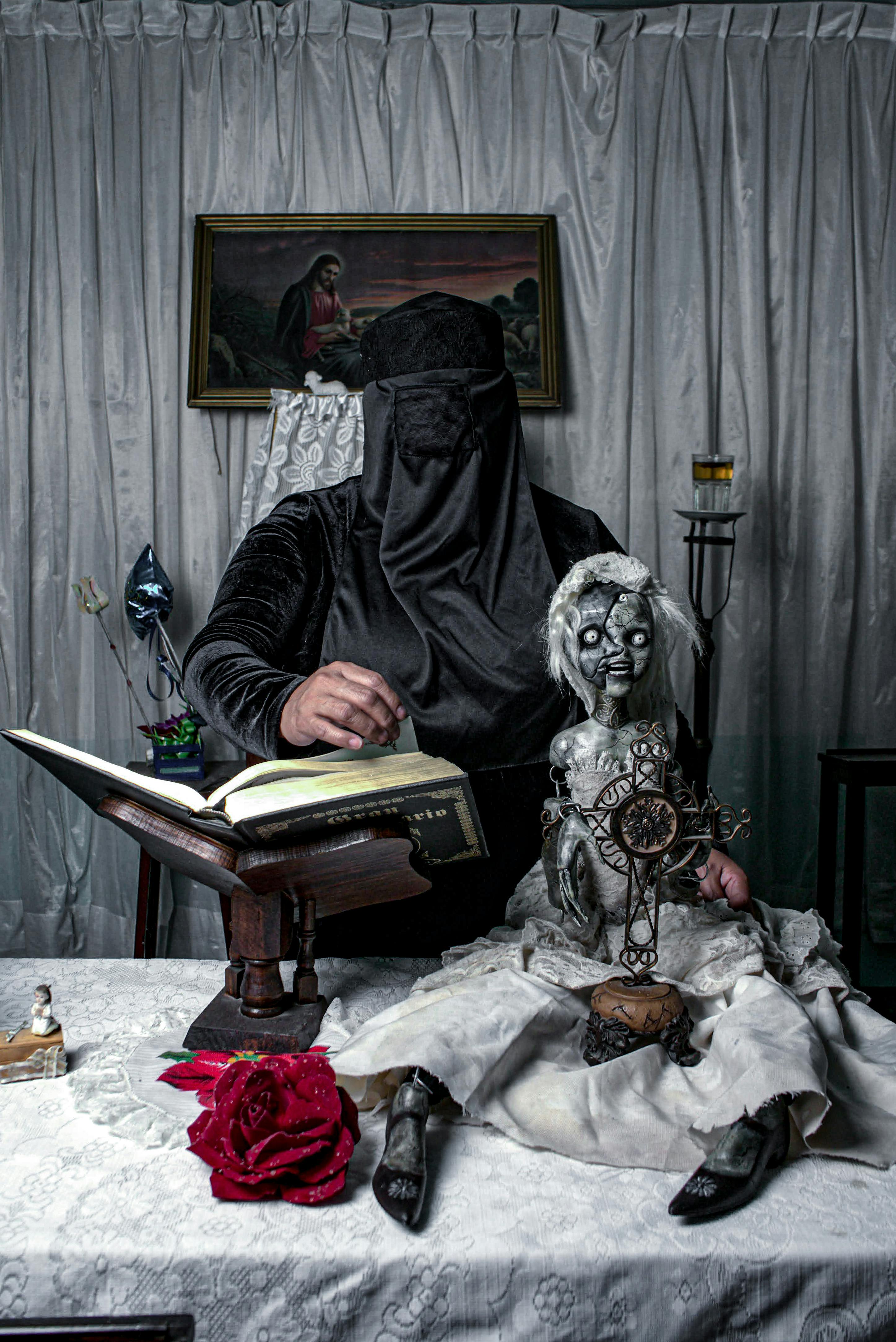 mysterious figure with creepy doll and book