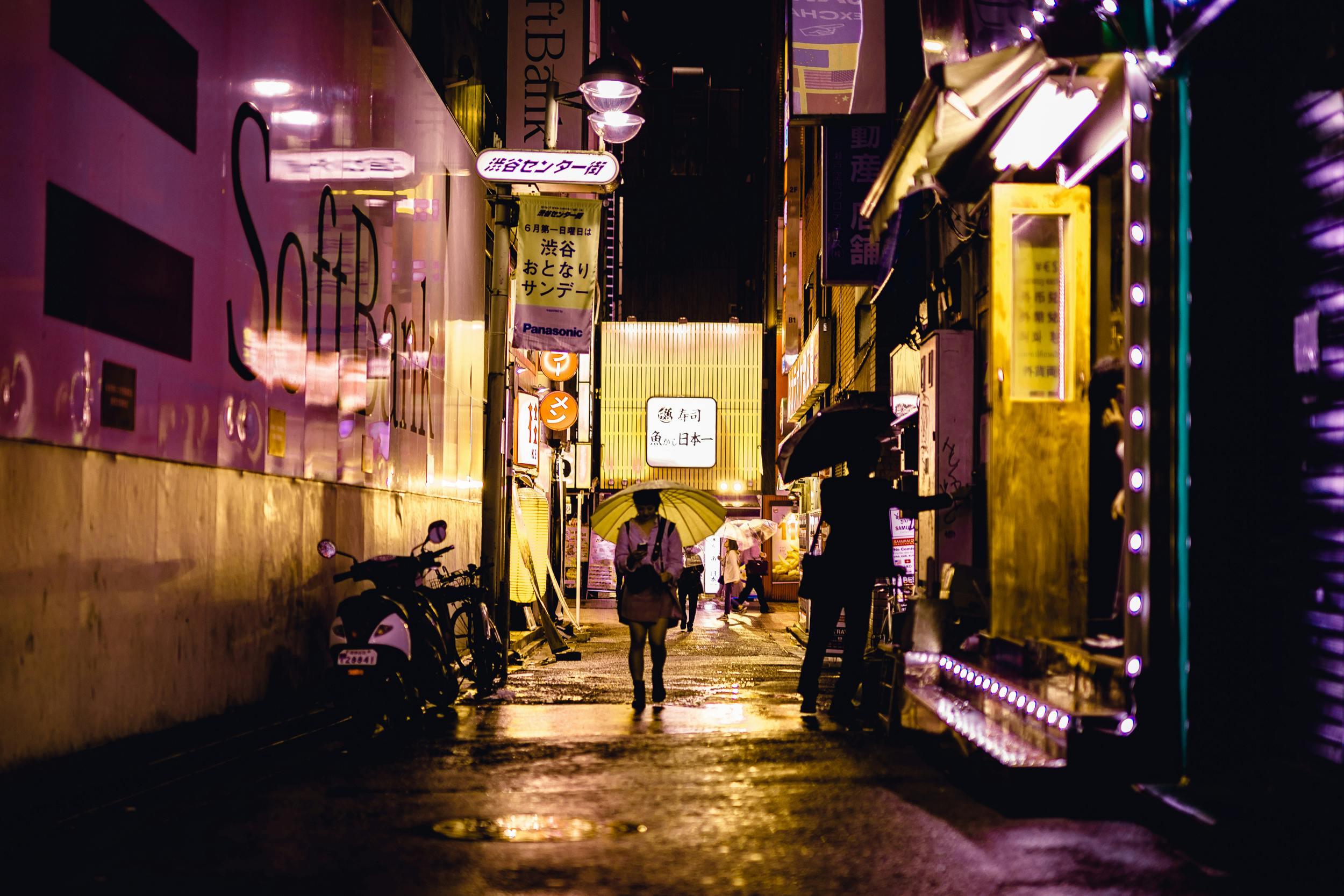 people walking near road beside buildings during night time