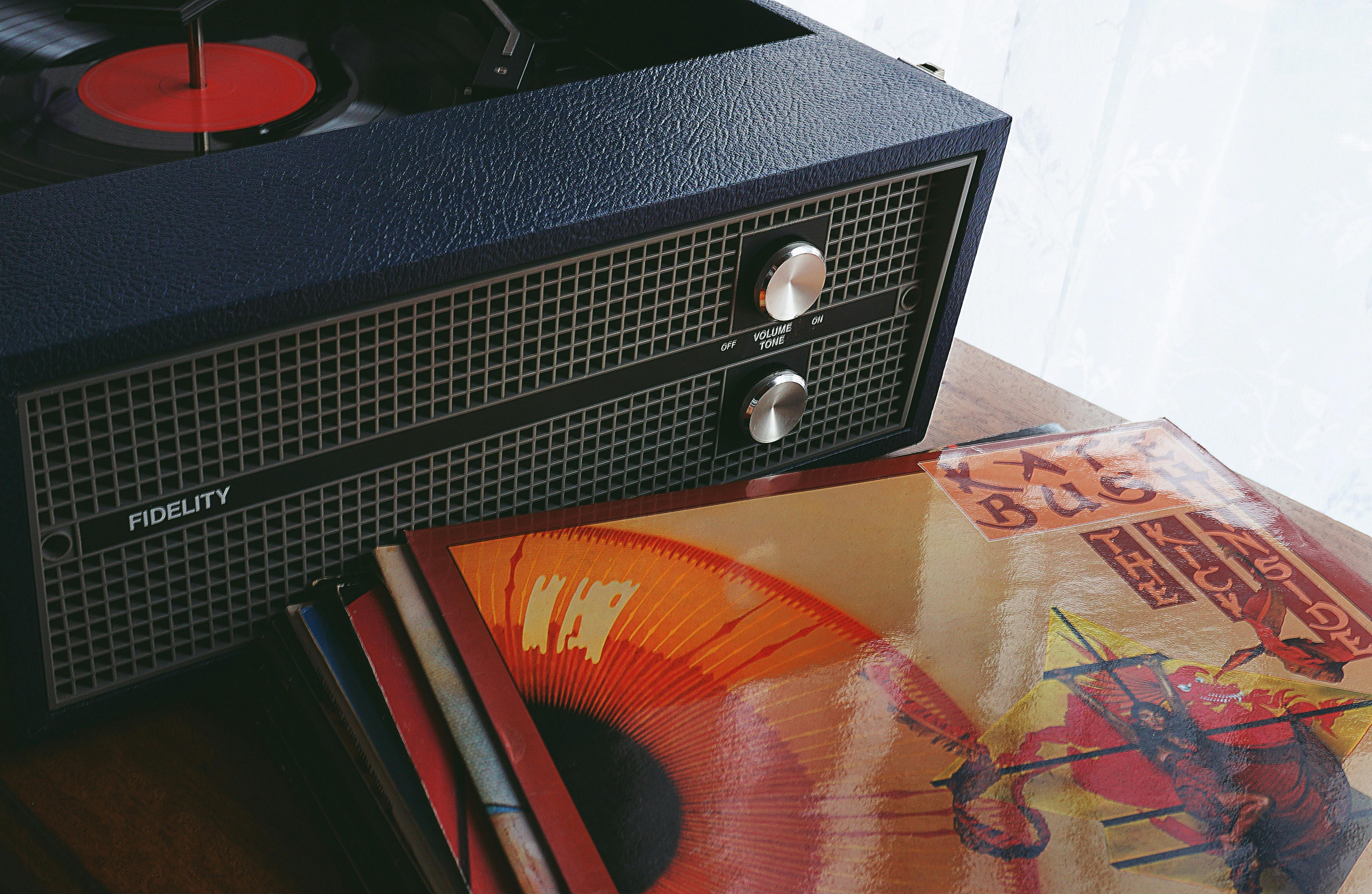 black speaker beside vinyl sleeve