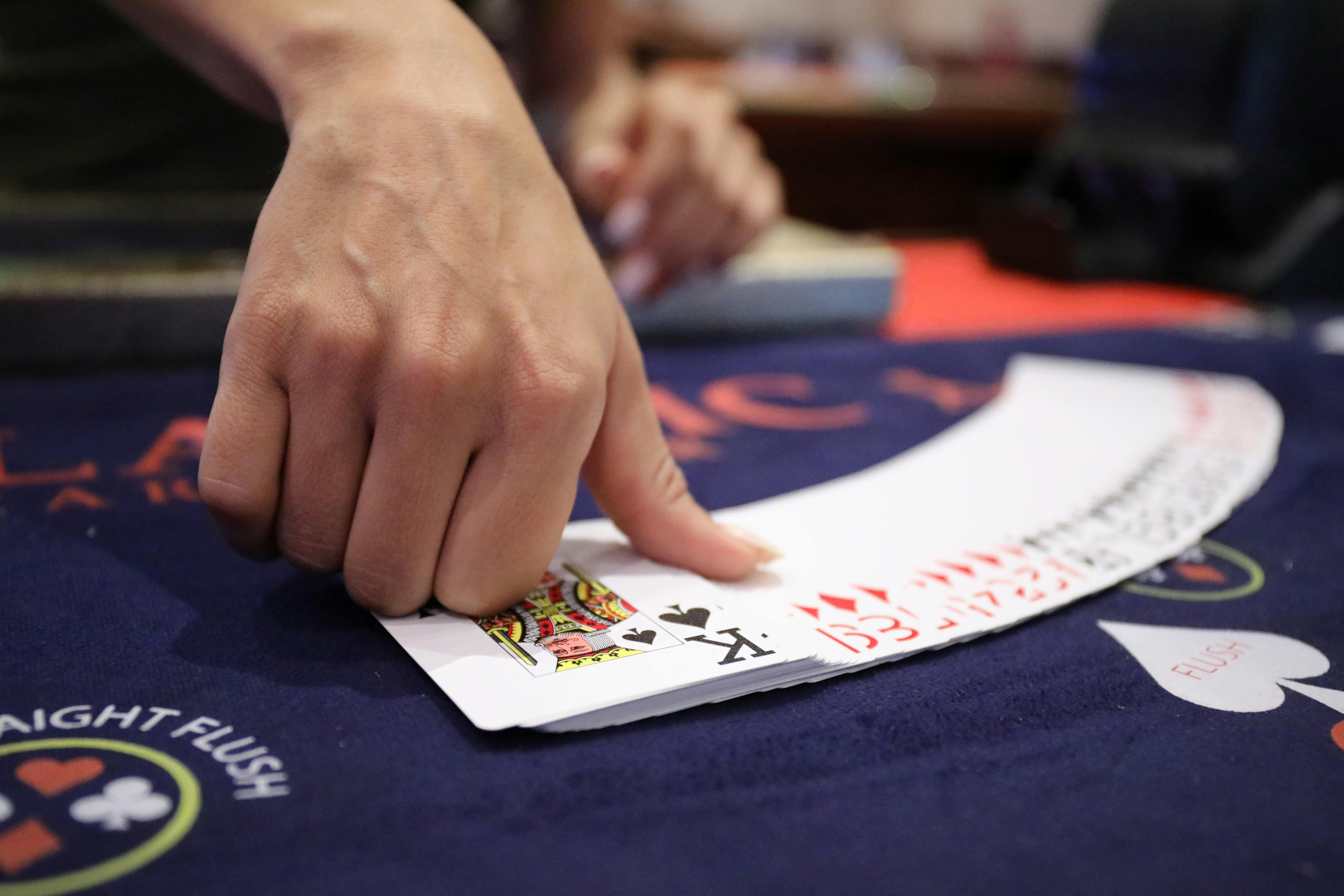 a person spreading playing cards on the table