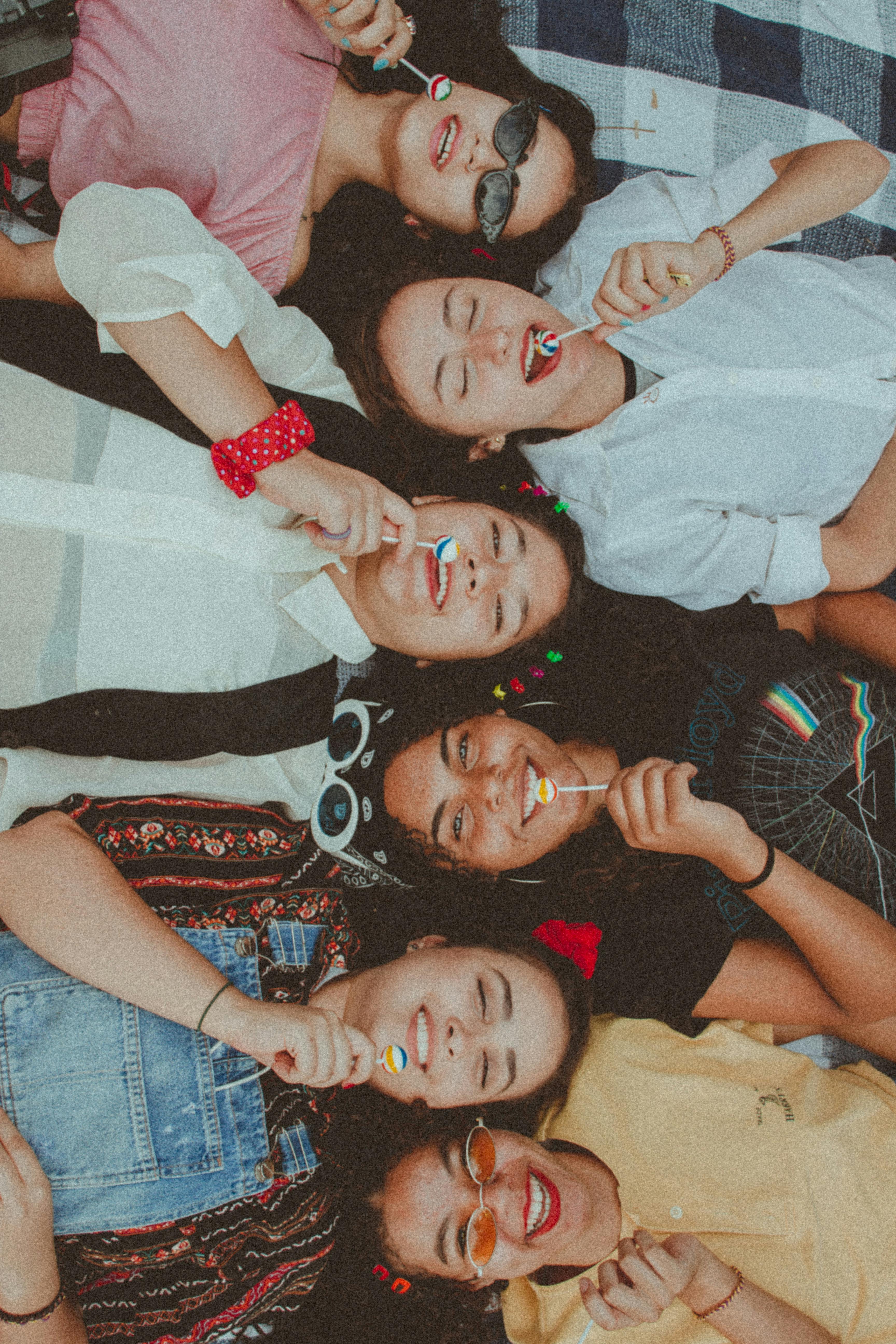 women lying down eating lollipop