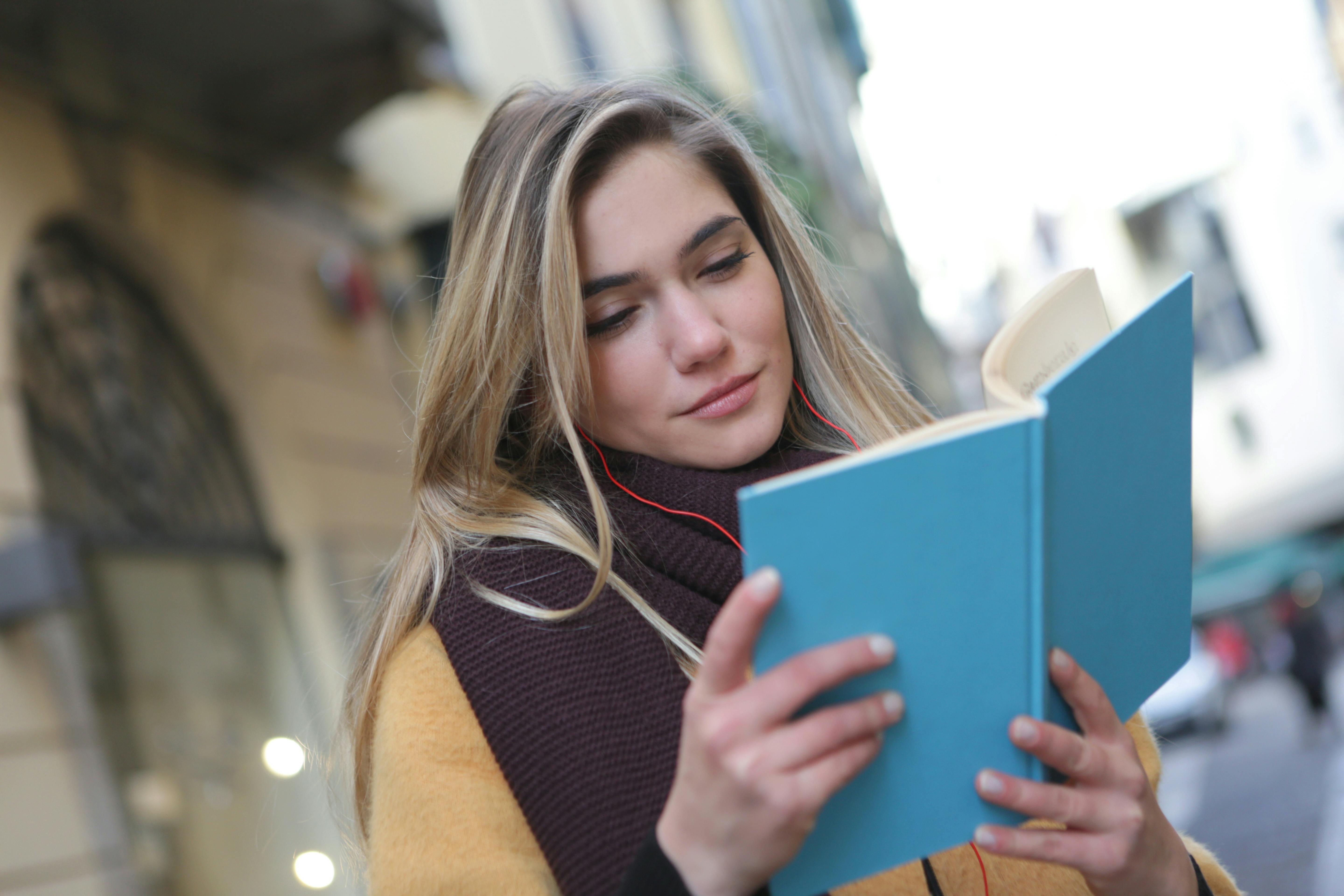 woman in purple scarf reading a book