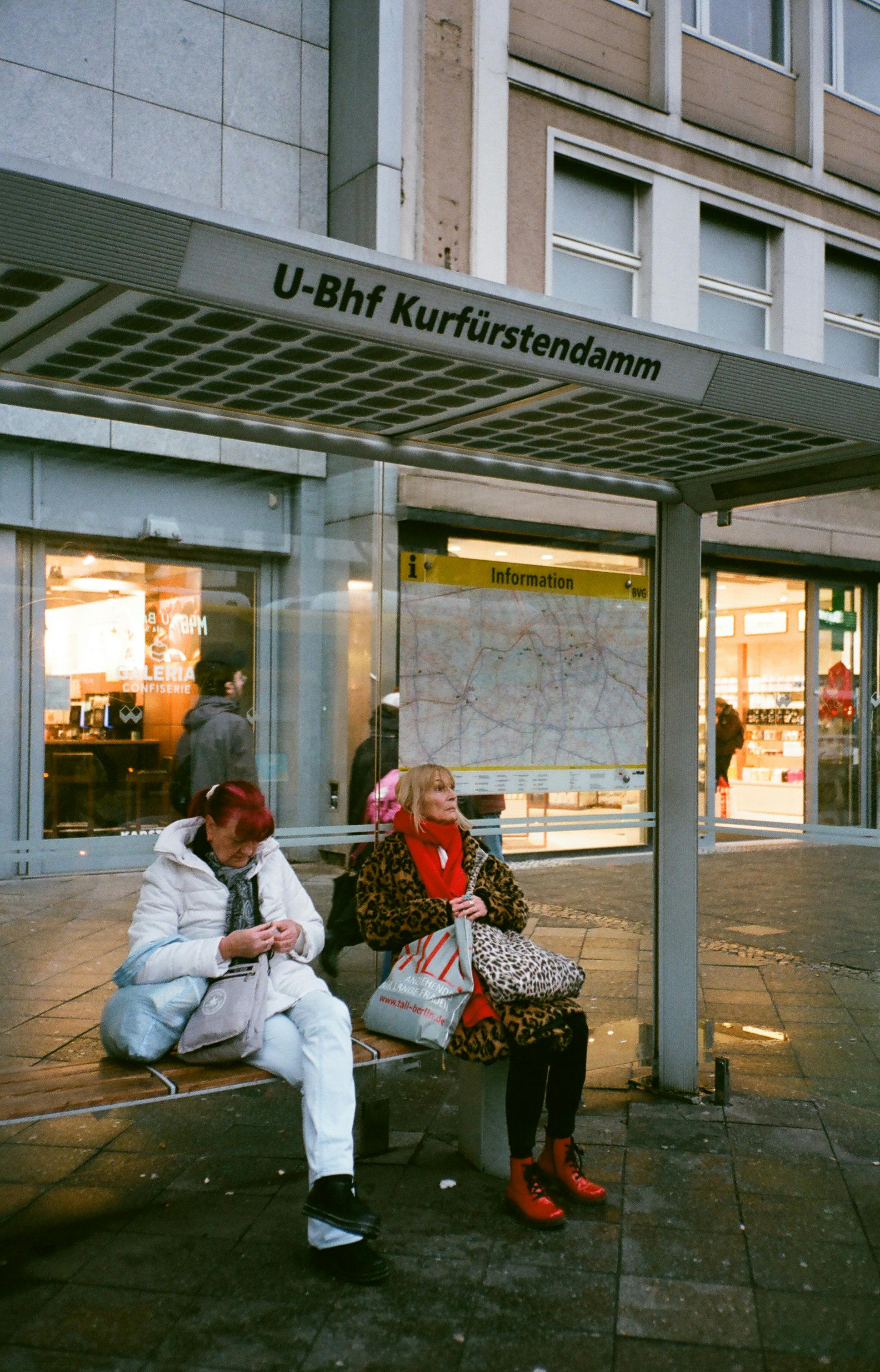 women waiting for bus on station in city