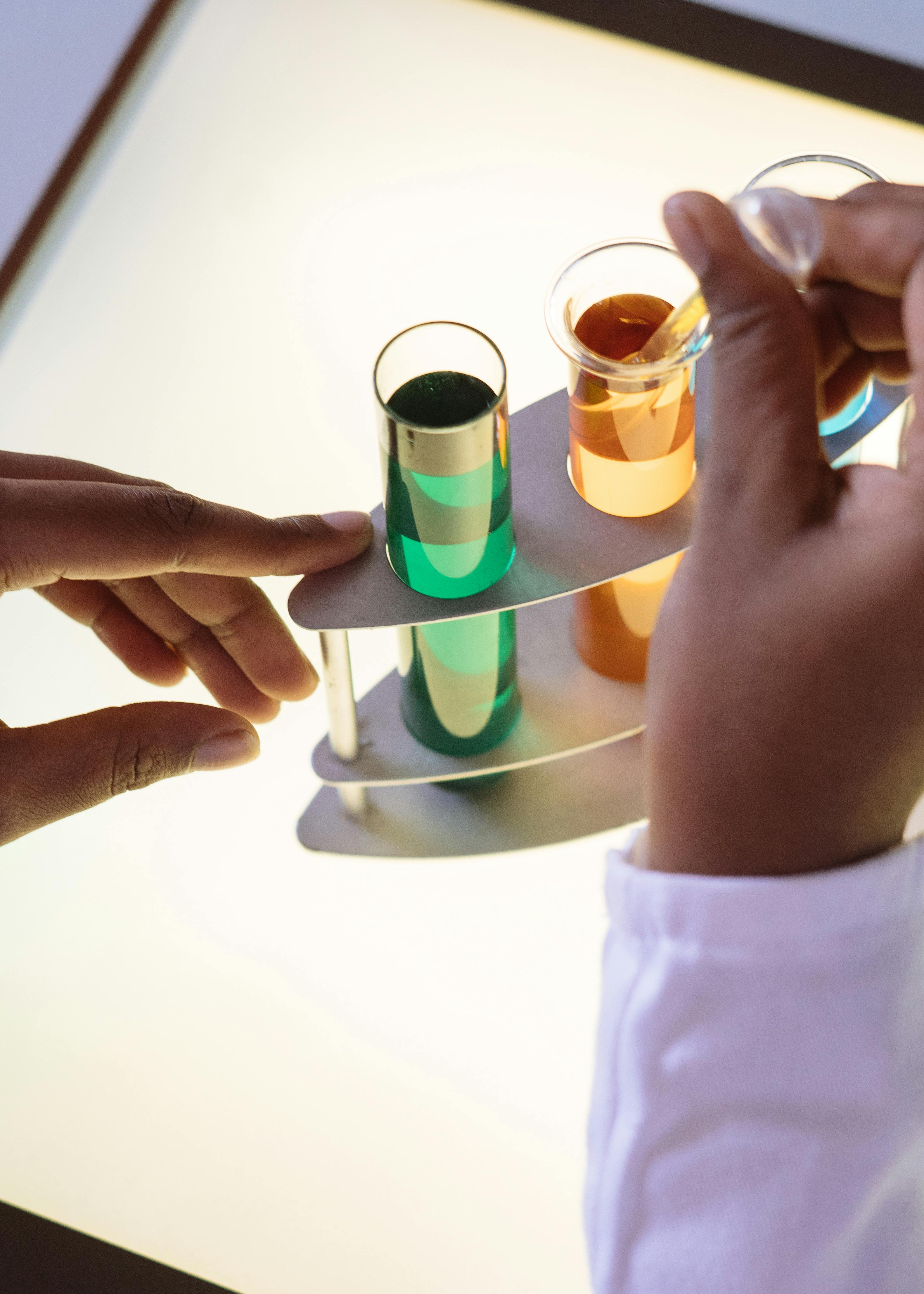 unrecognizable chemist taking liquid with pipette from test tube in modern laboratory