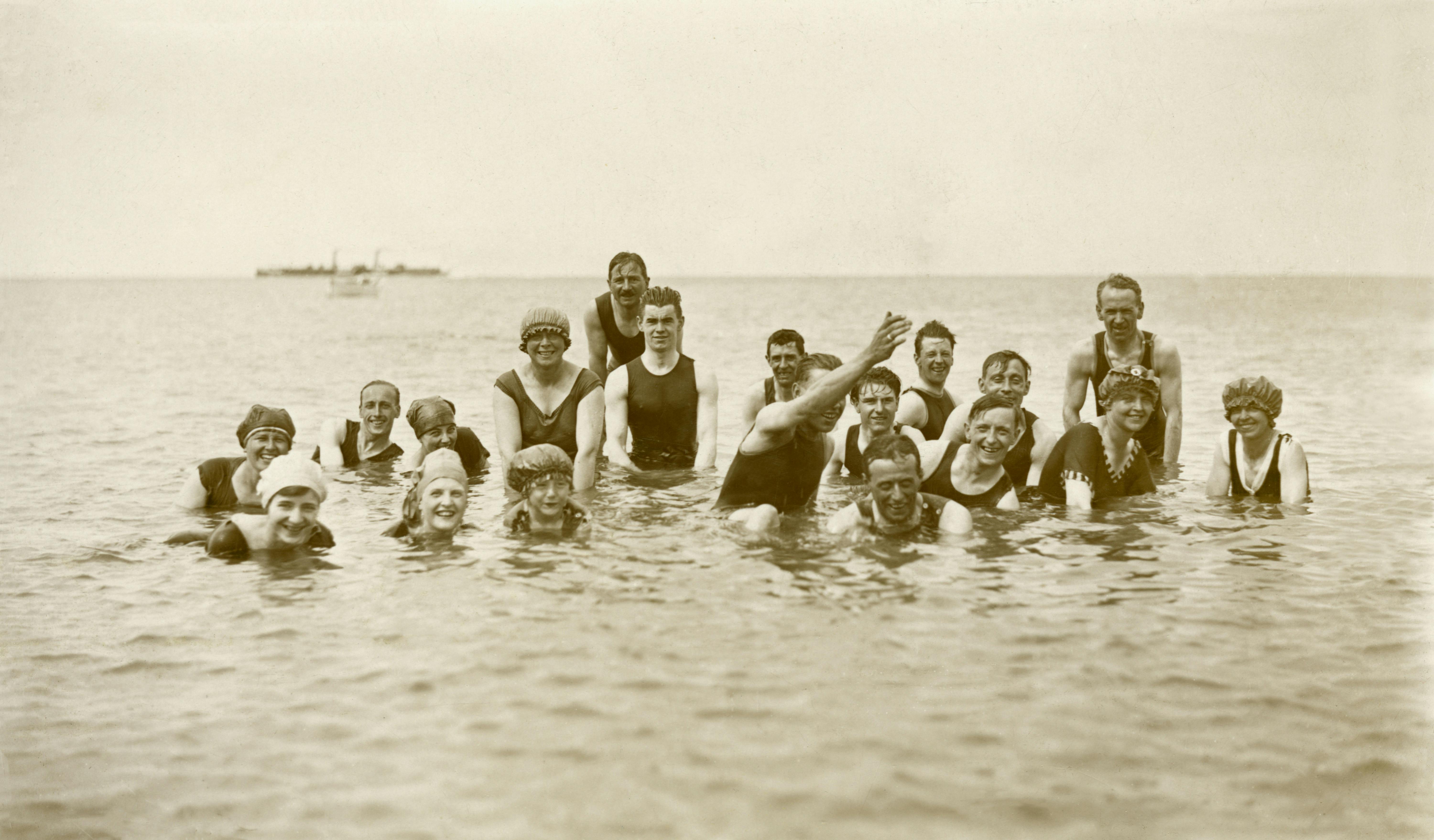 grayscale photo of group of people on water