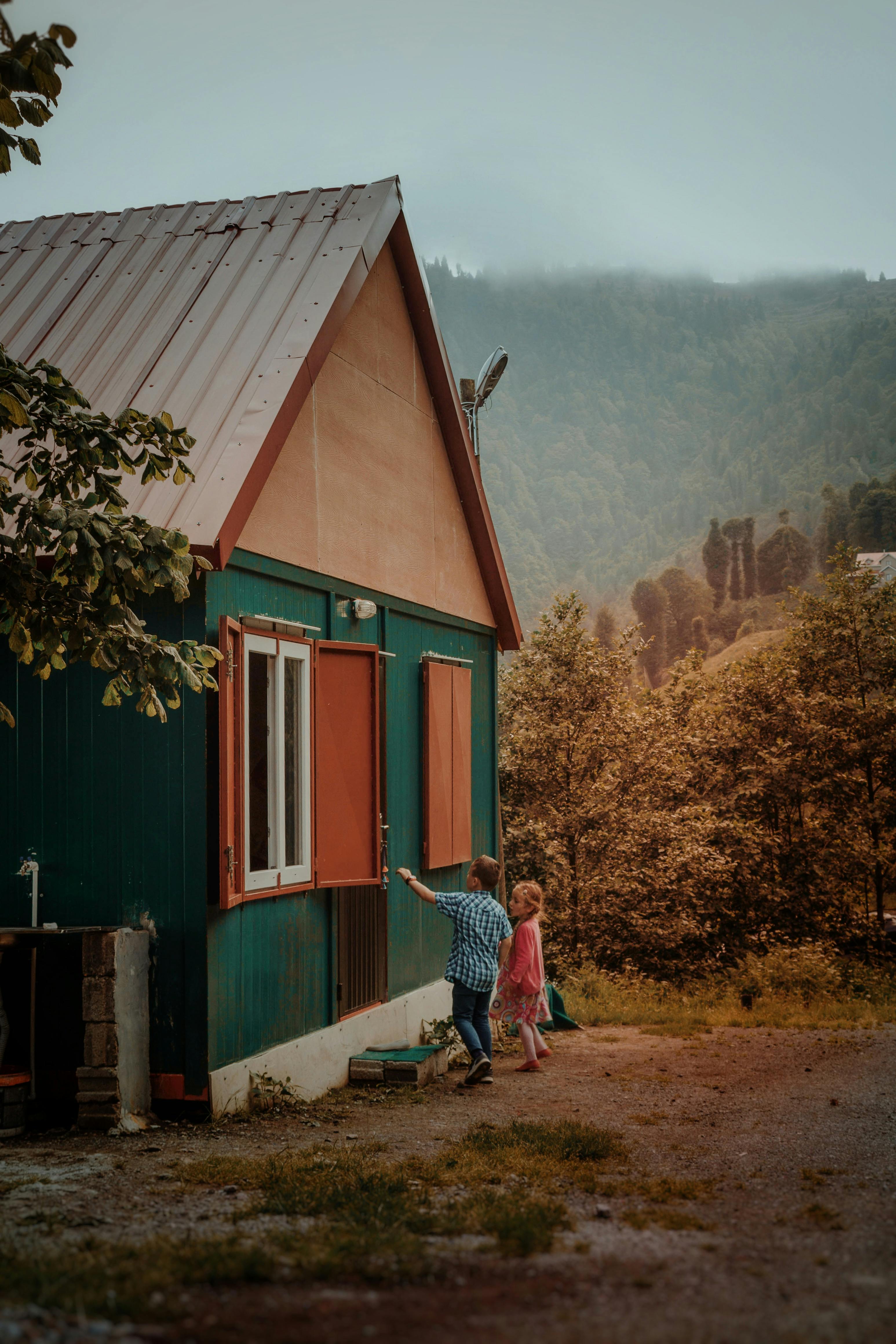 unrecognizable children standing near village house