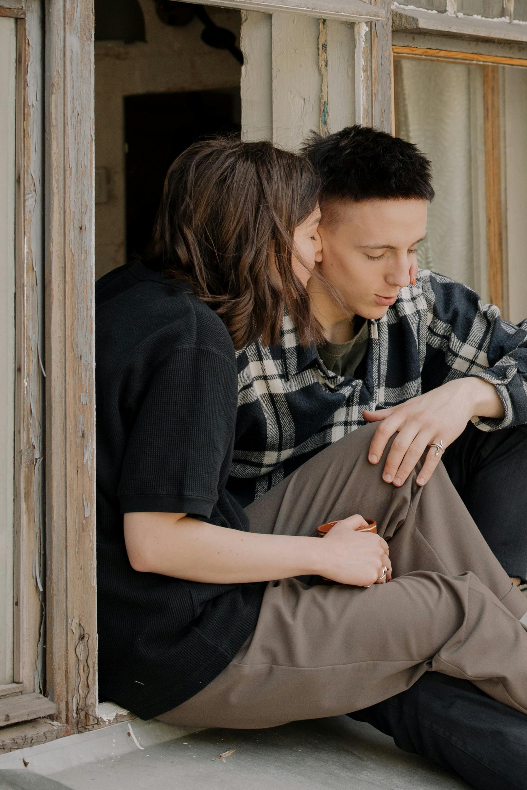 man in black and white plaid shirt hugging woman in black long sleeve shirt