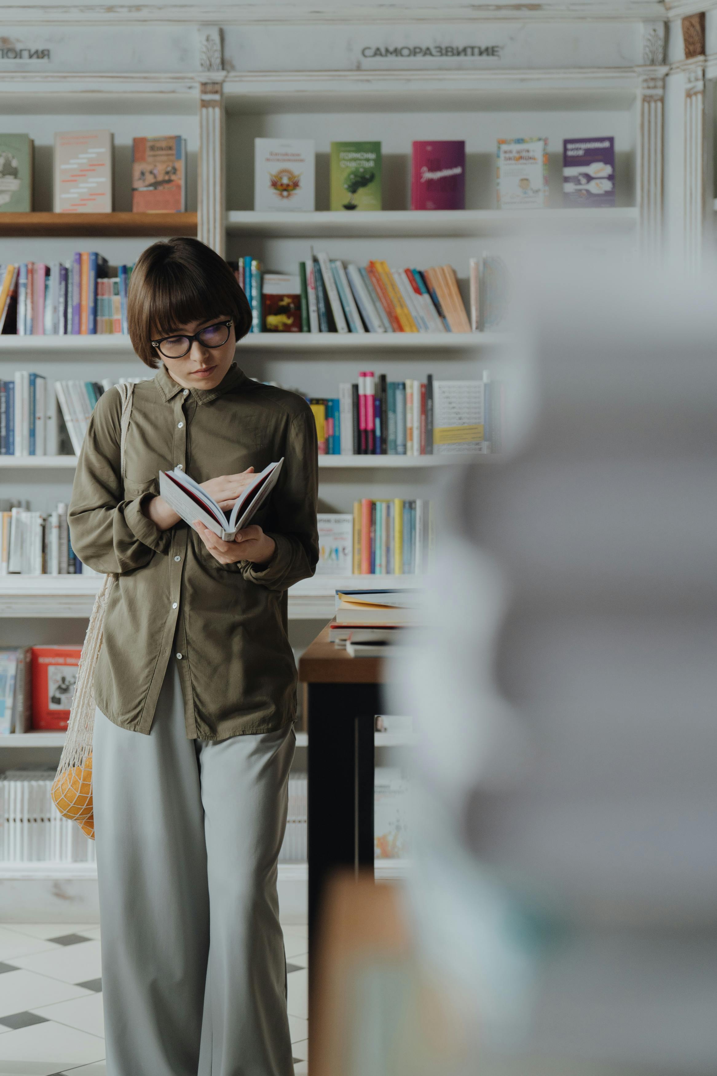 woman in brown coat holding book