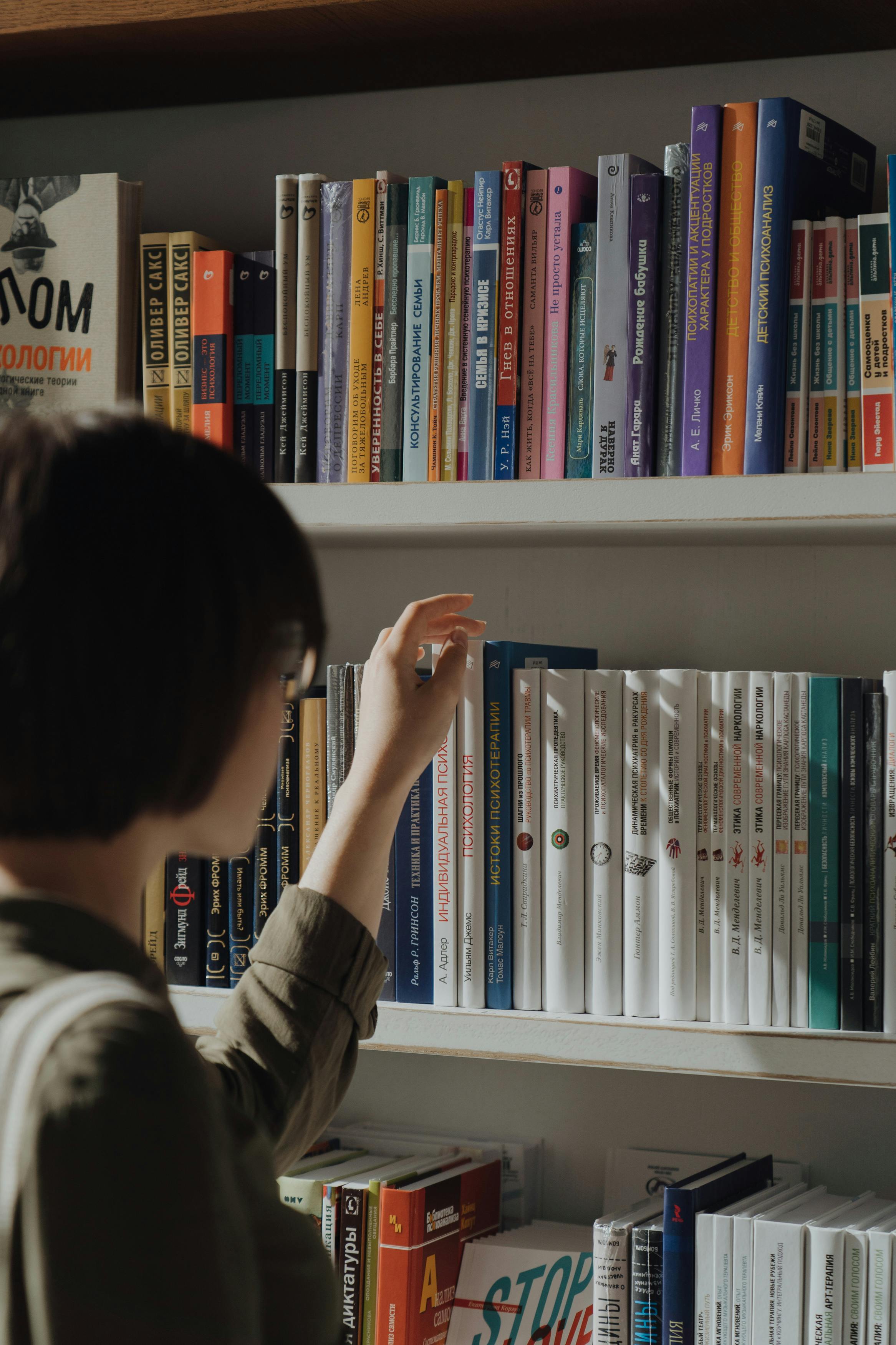 person in black and white long sleeve shirt holding white book