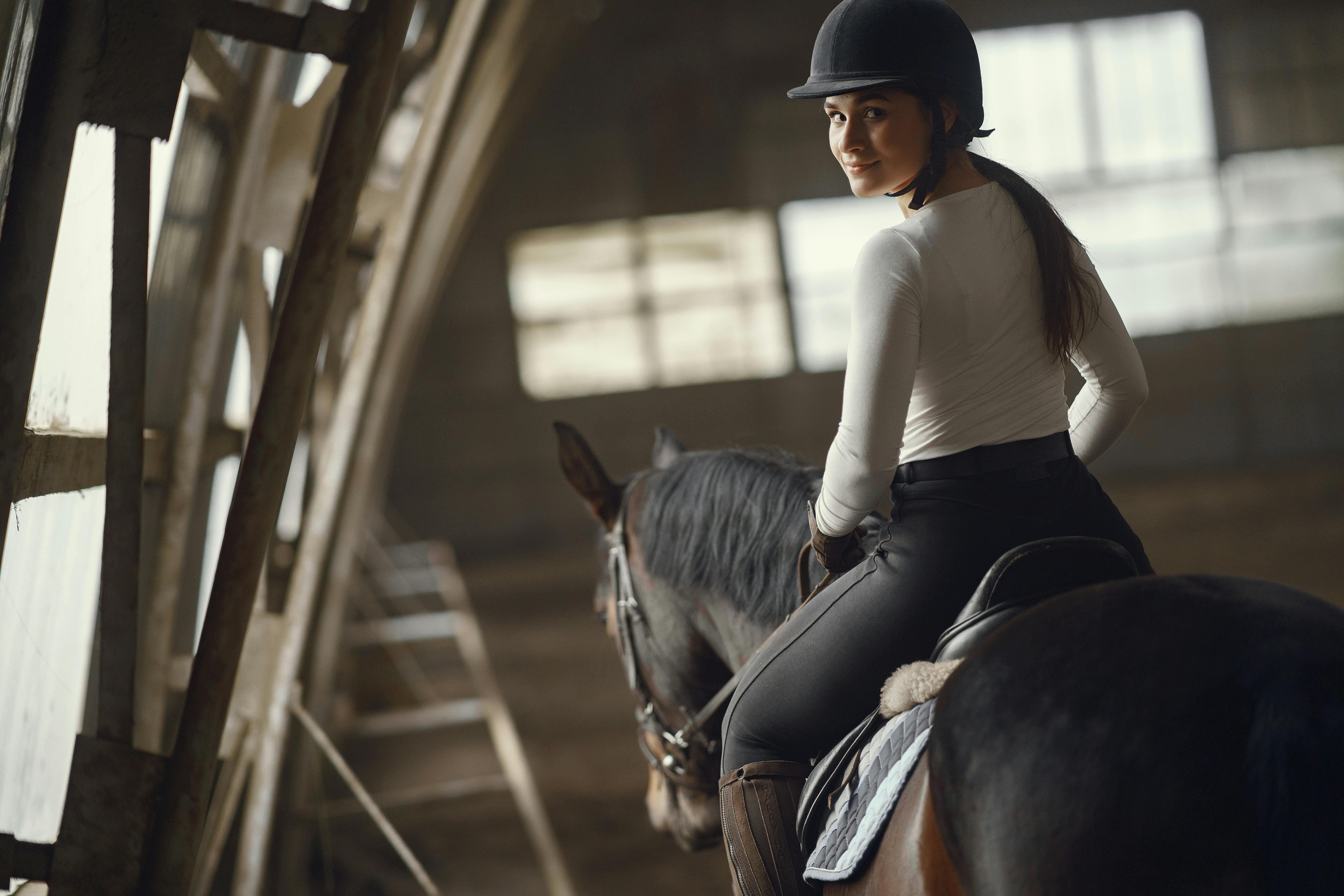 woman in white shirt riding a horse