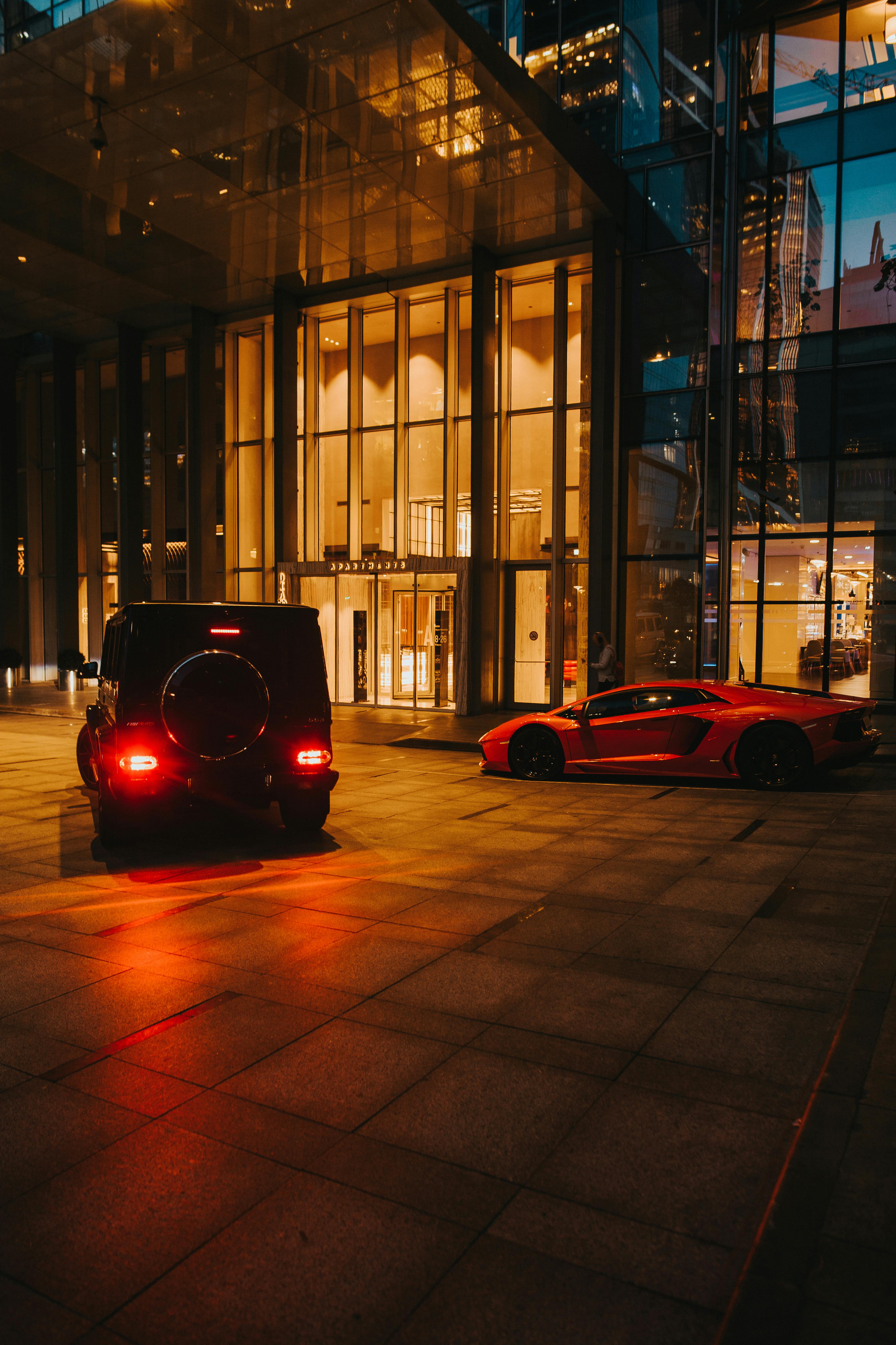 cars on a driveway beside a building