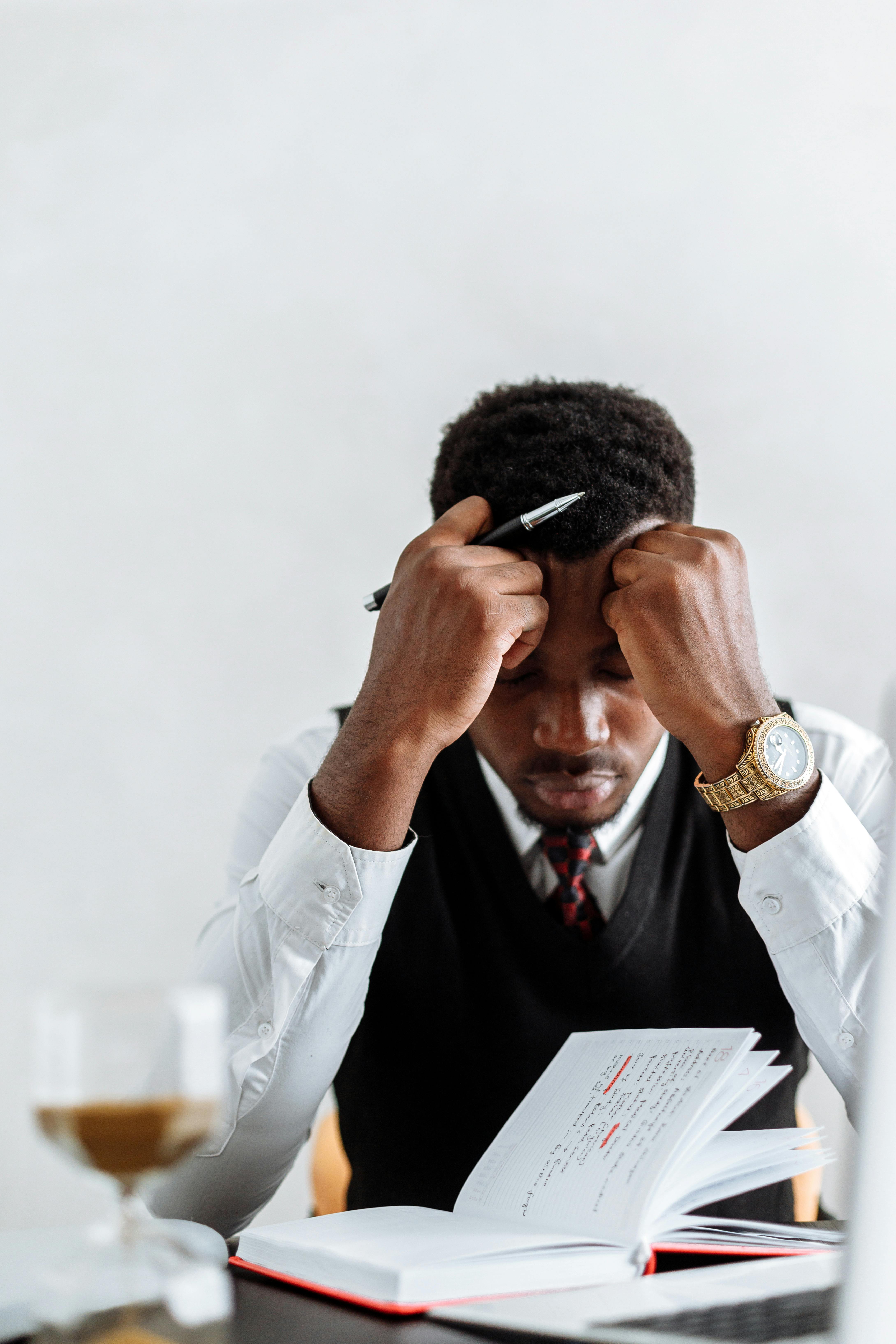 man in white dress shirt holding black smartphone