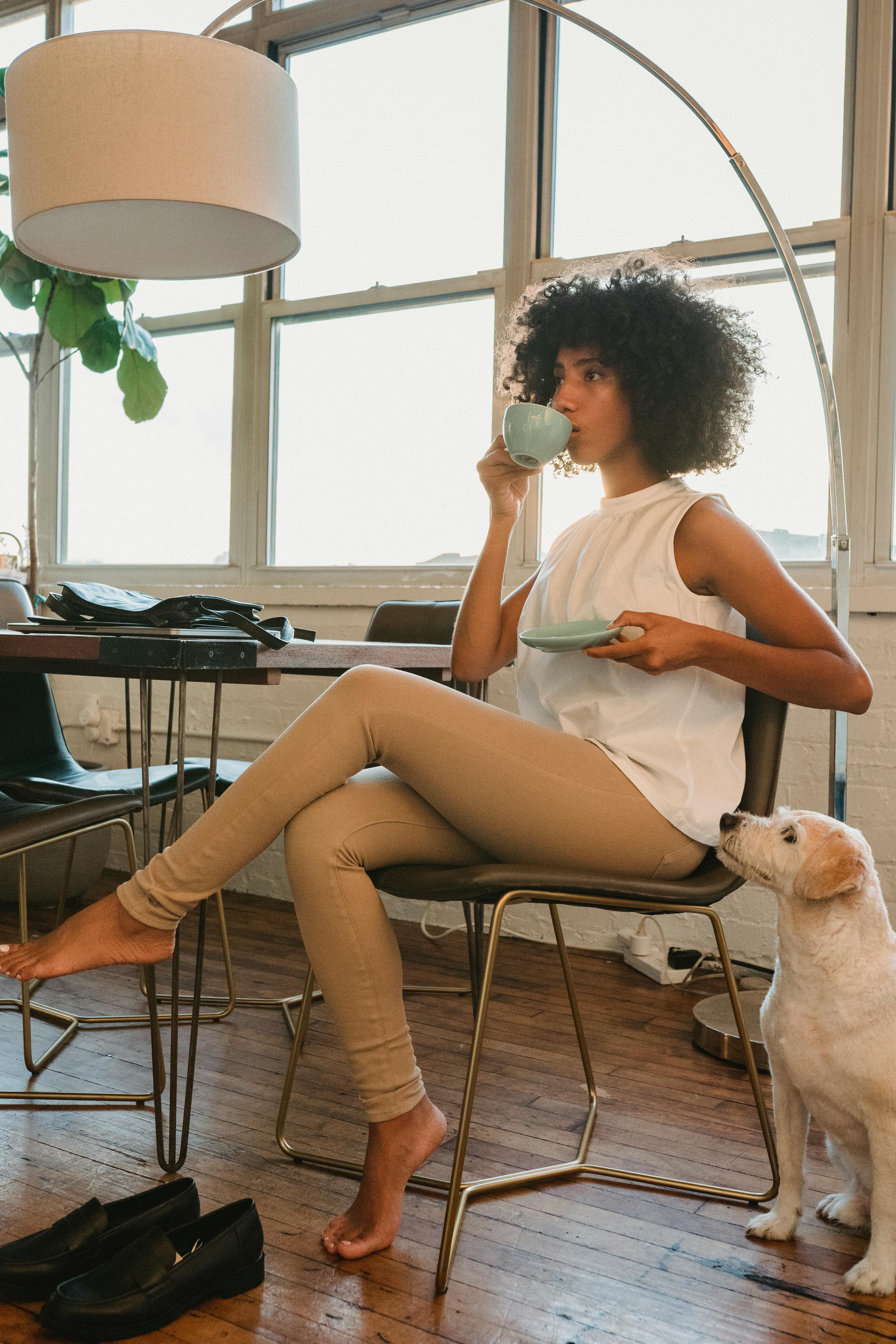 relaxed black woman with coffee and dog