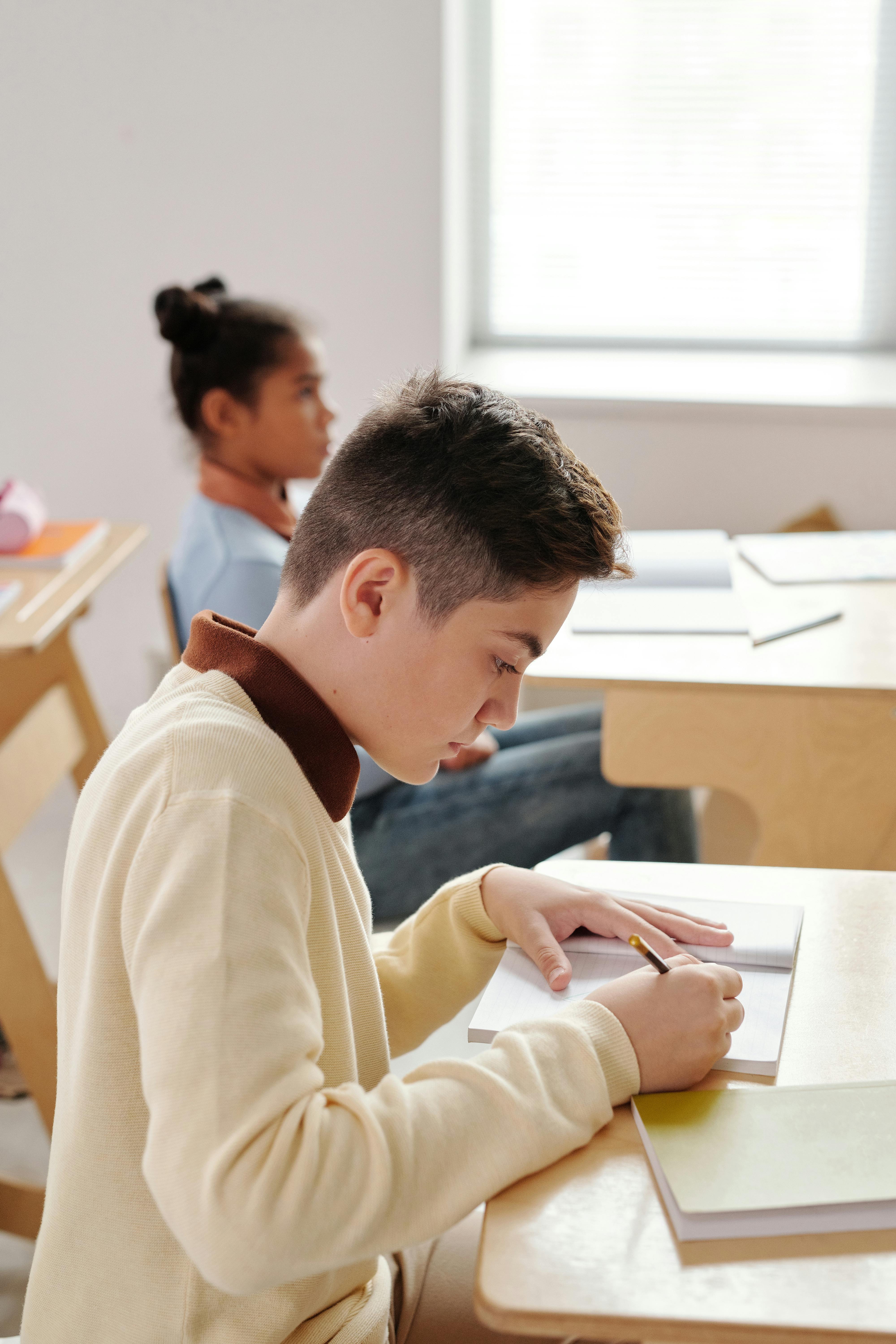 boy writing on his notebook