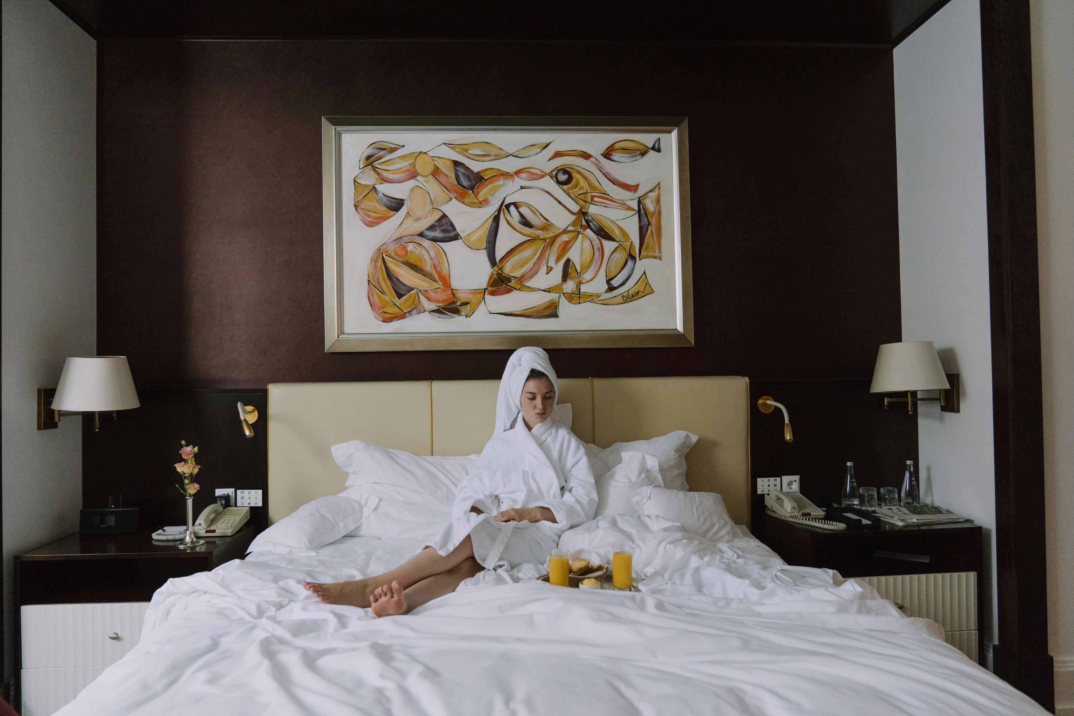 woman in bathrobe sitting on bed