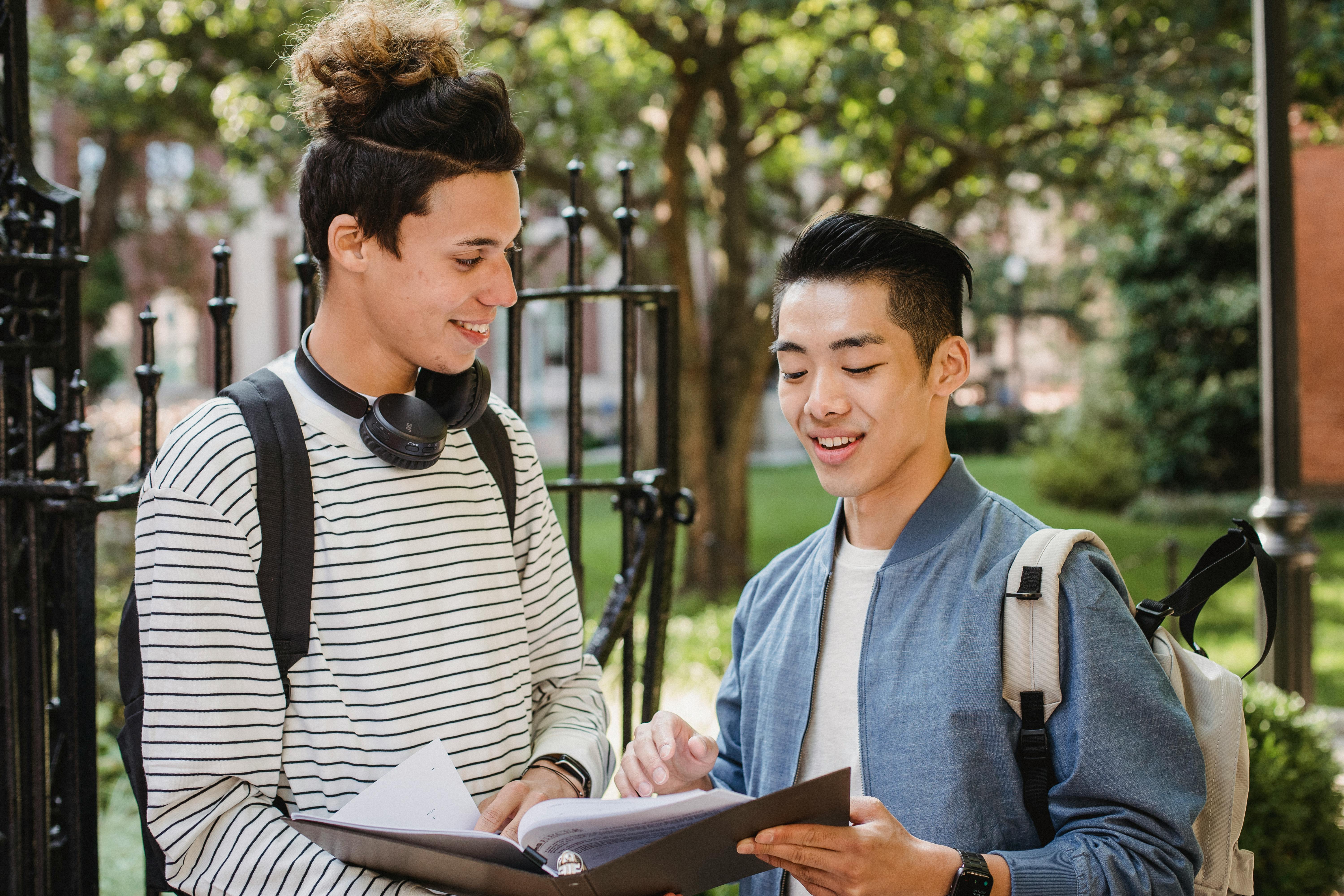 cheerful multiethnic students sharing information about studies