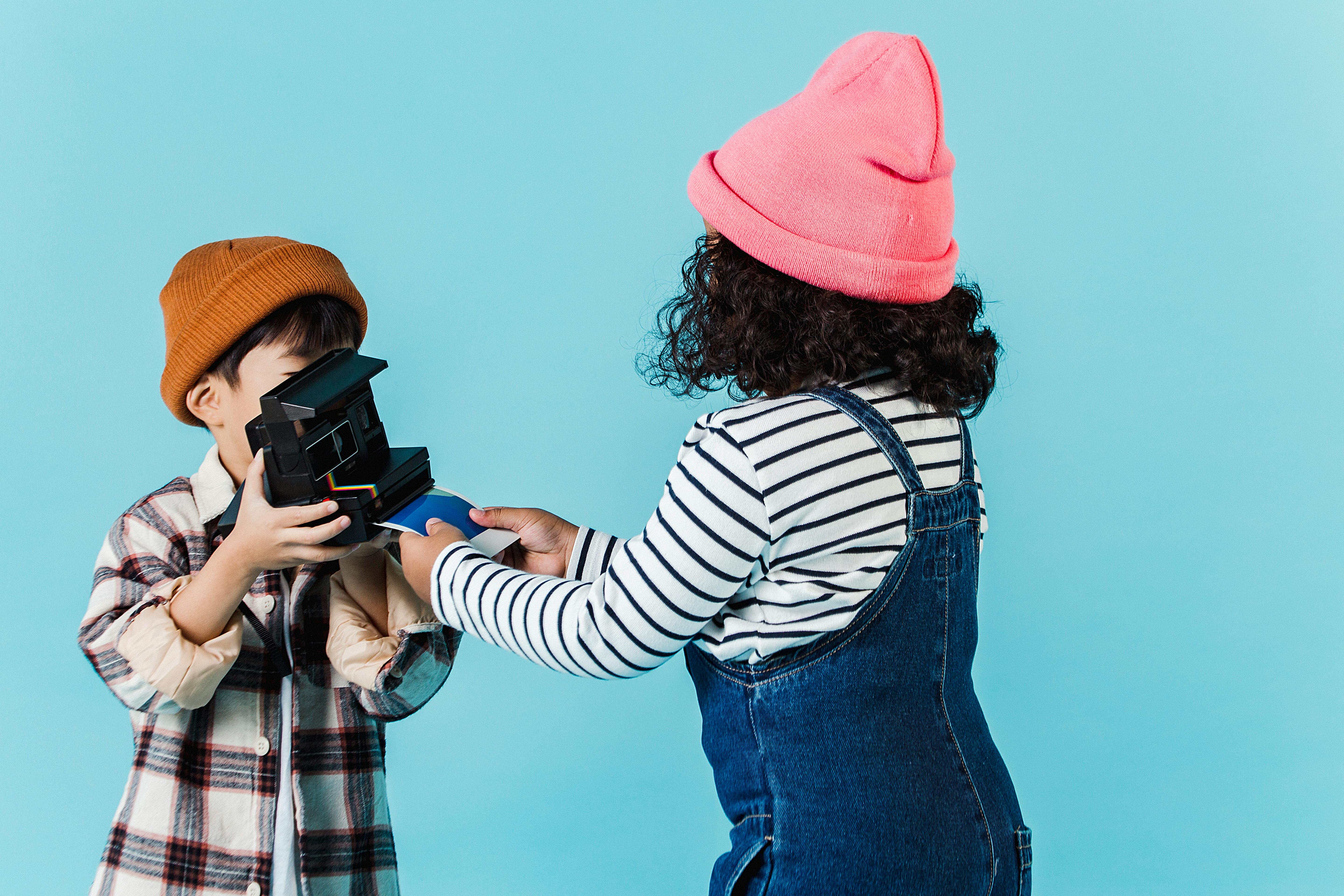 children taking instant photo on vintage camera in studio