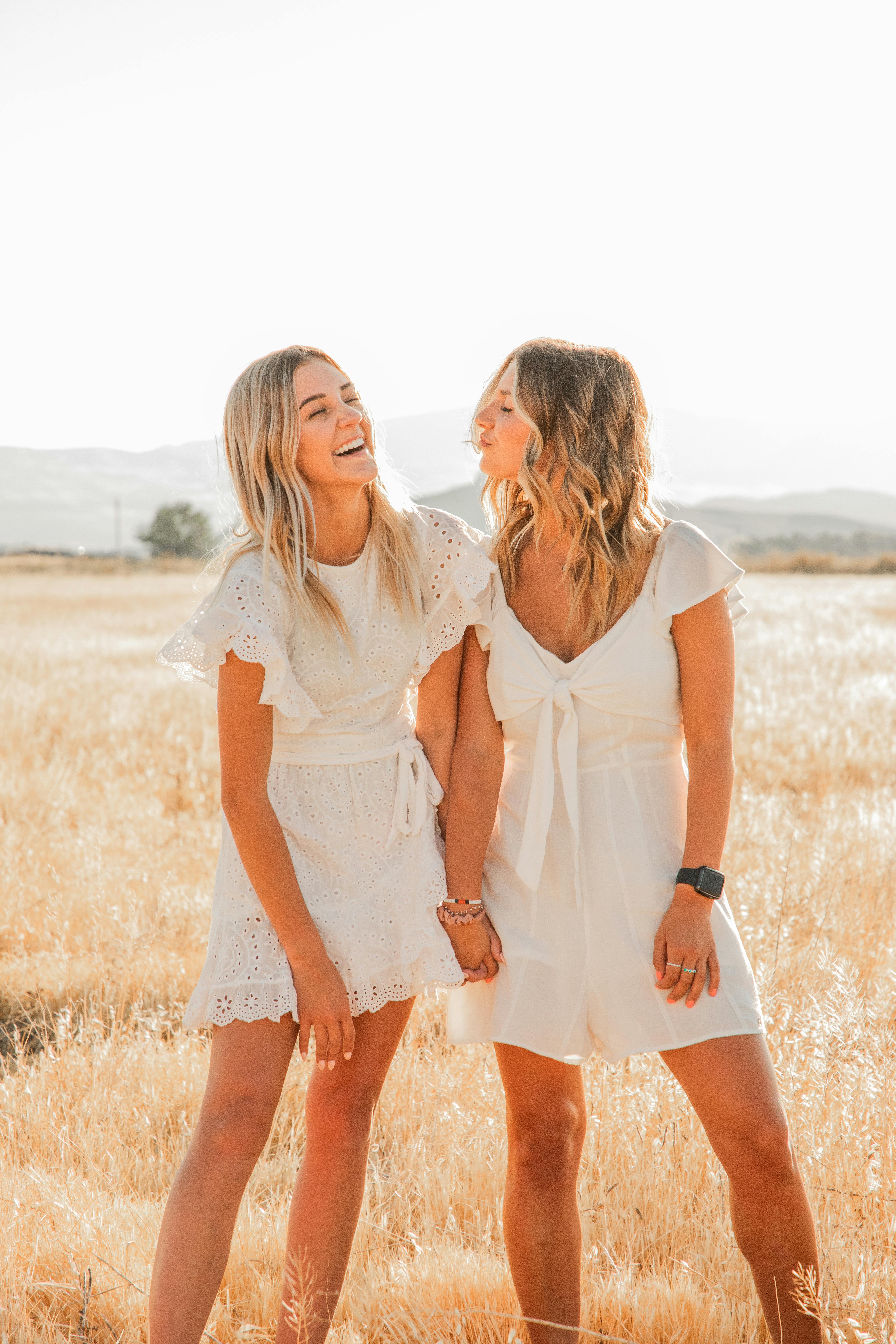 happy trendy girlfriends having fun in countryside field