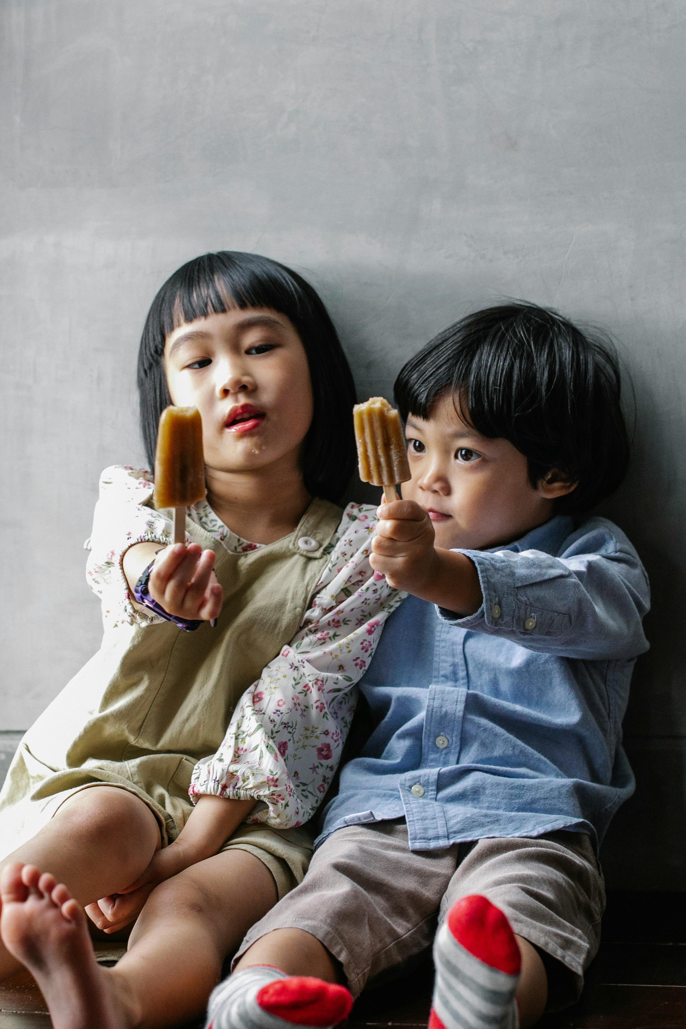 asian children reaching out hands with ice creams