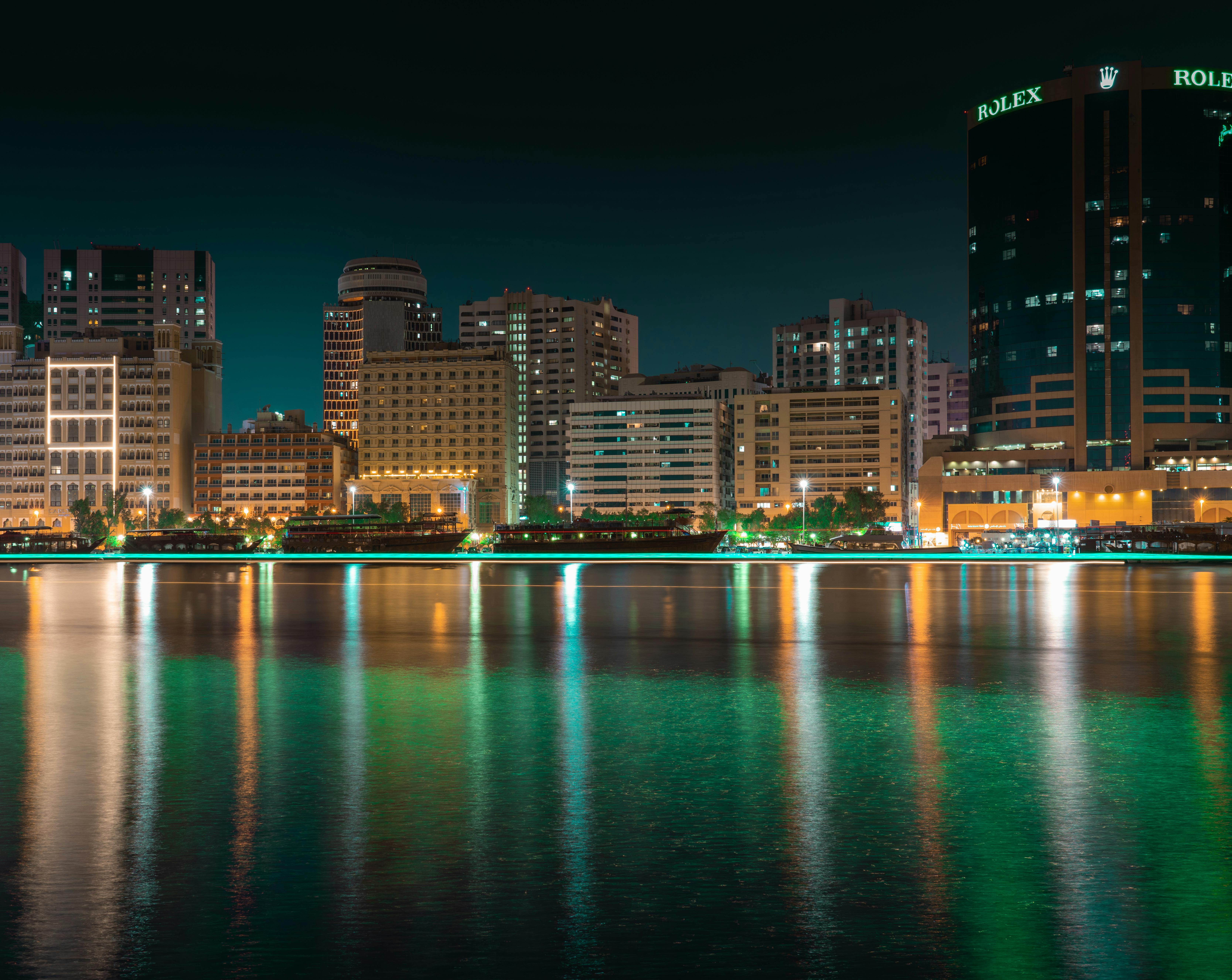 city skyline across body of water at night time