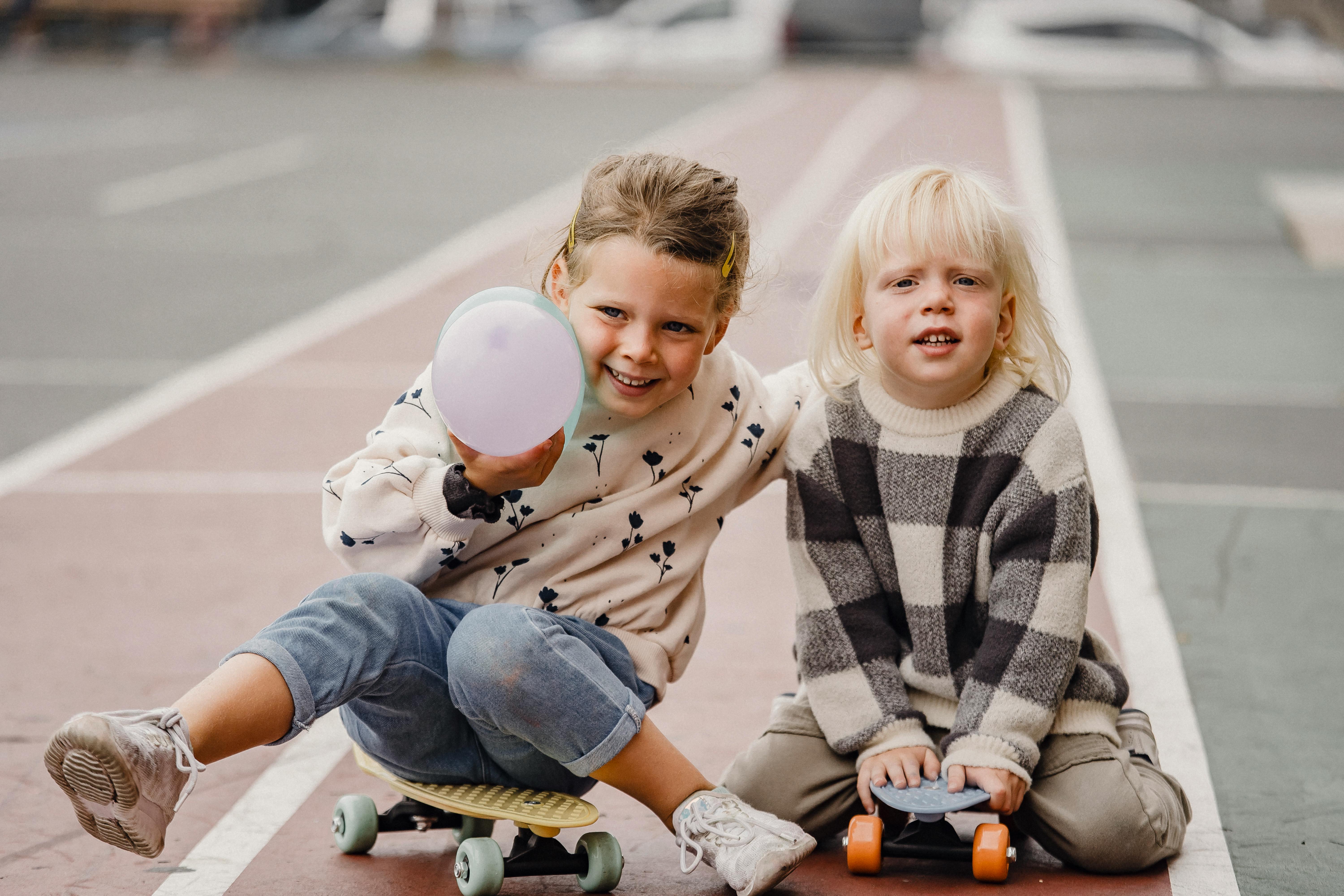 happy kids sitting on longboards outside