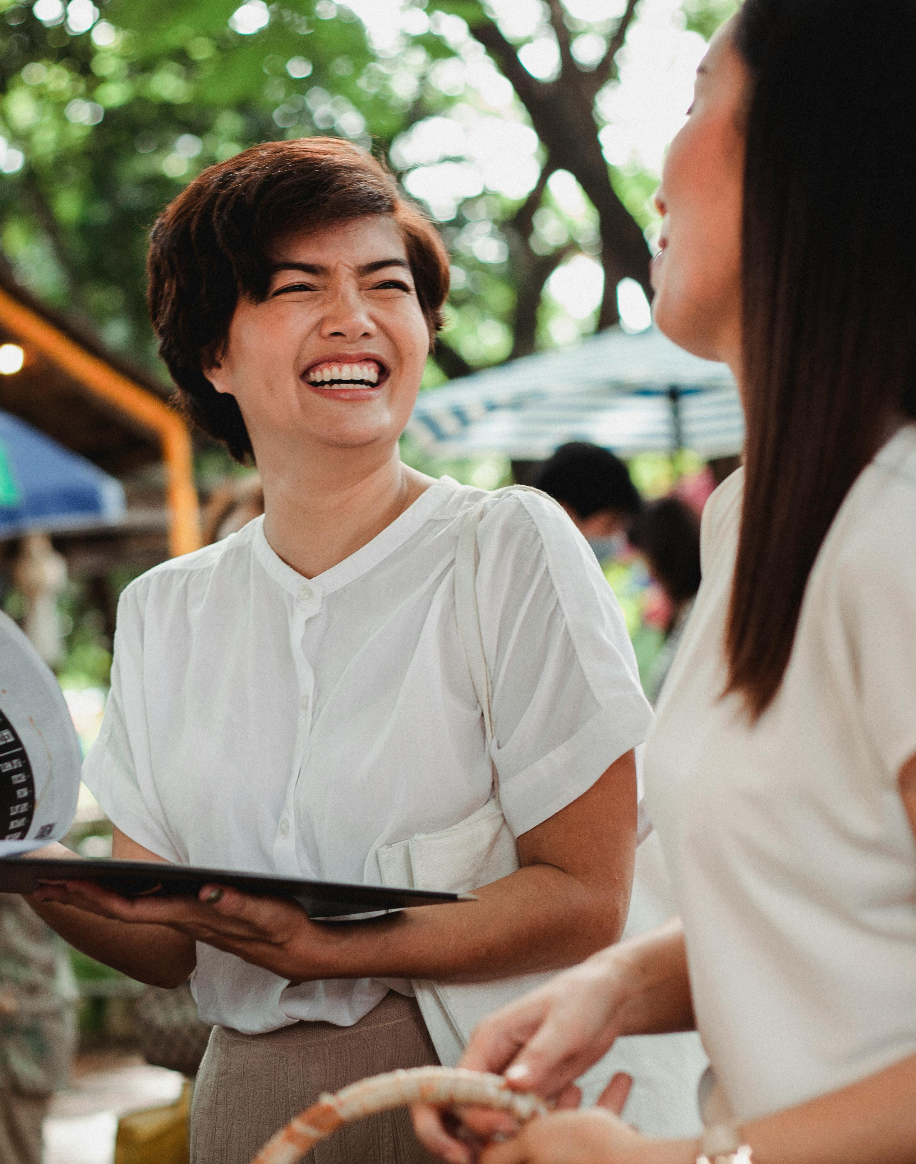 laughing asian women standing in street market