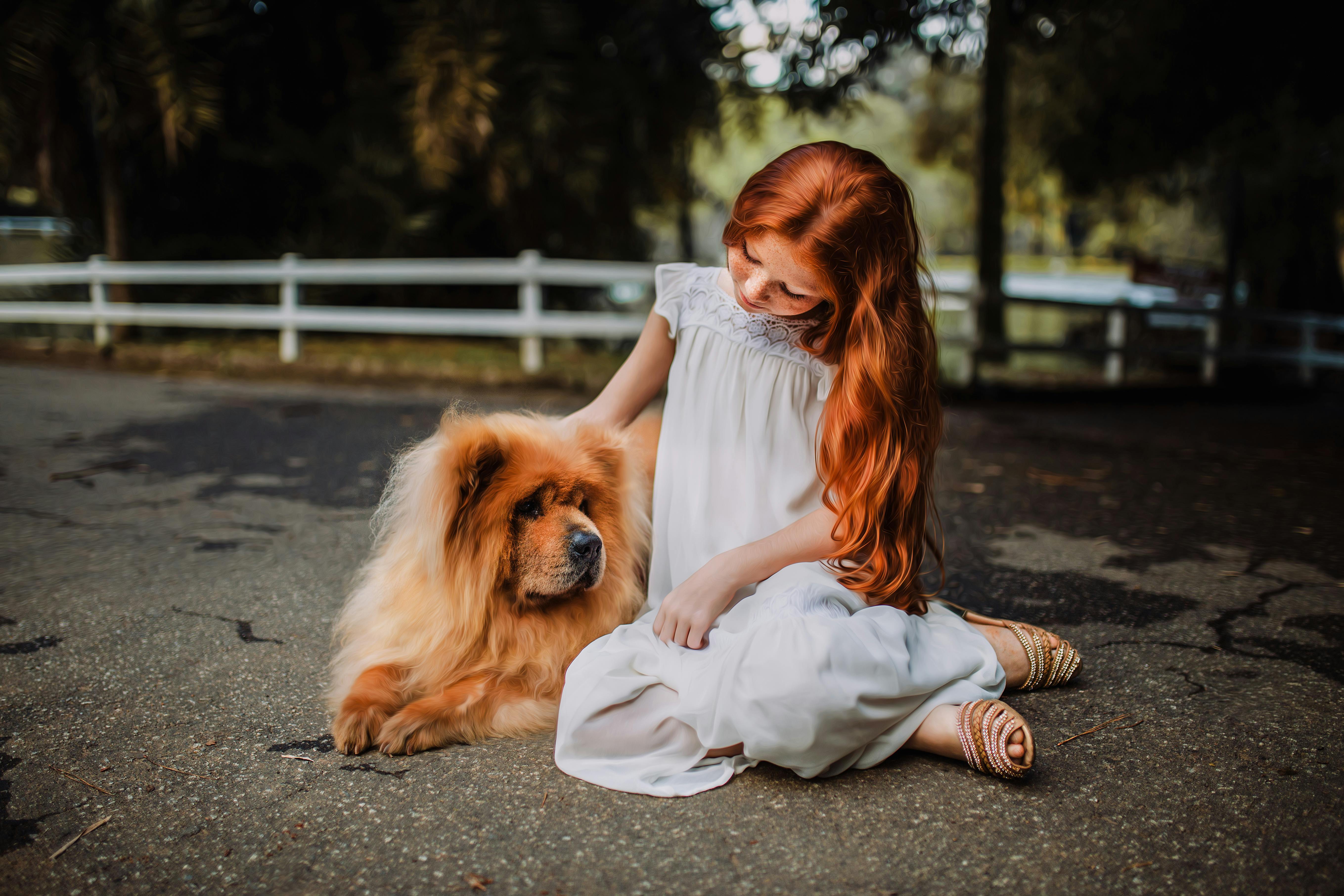 woman sitting beside chow chow on gray concrete