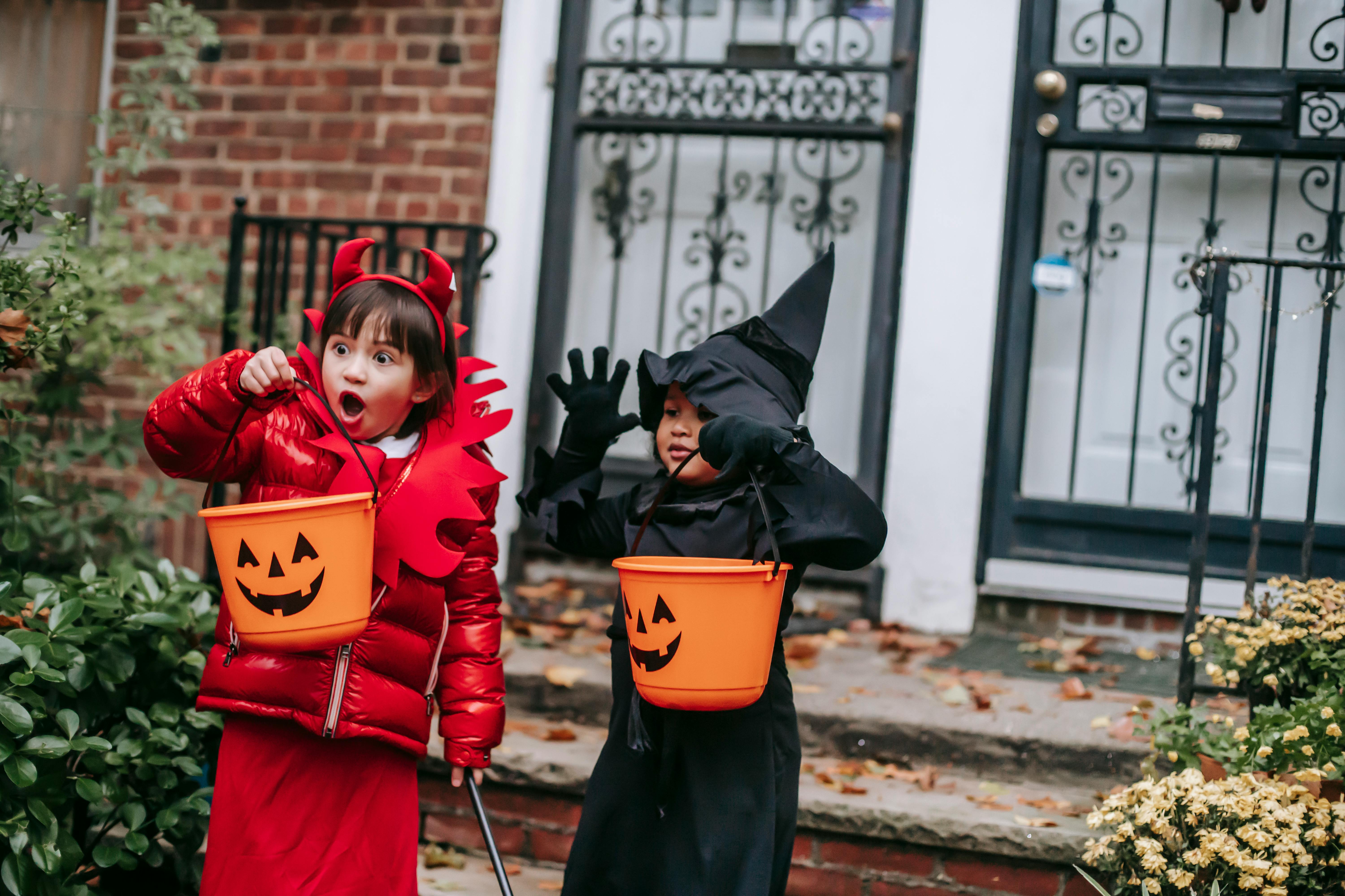 girls in halloween costumes making spooky faces at porch