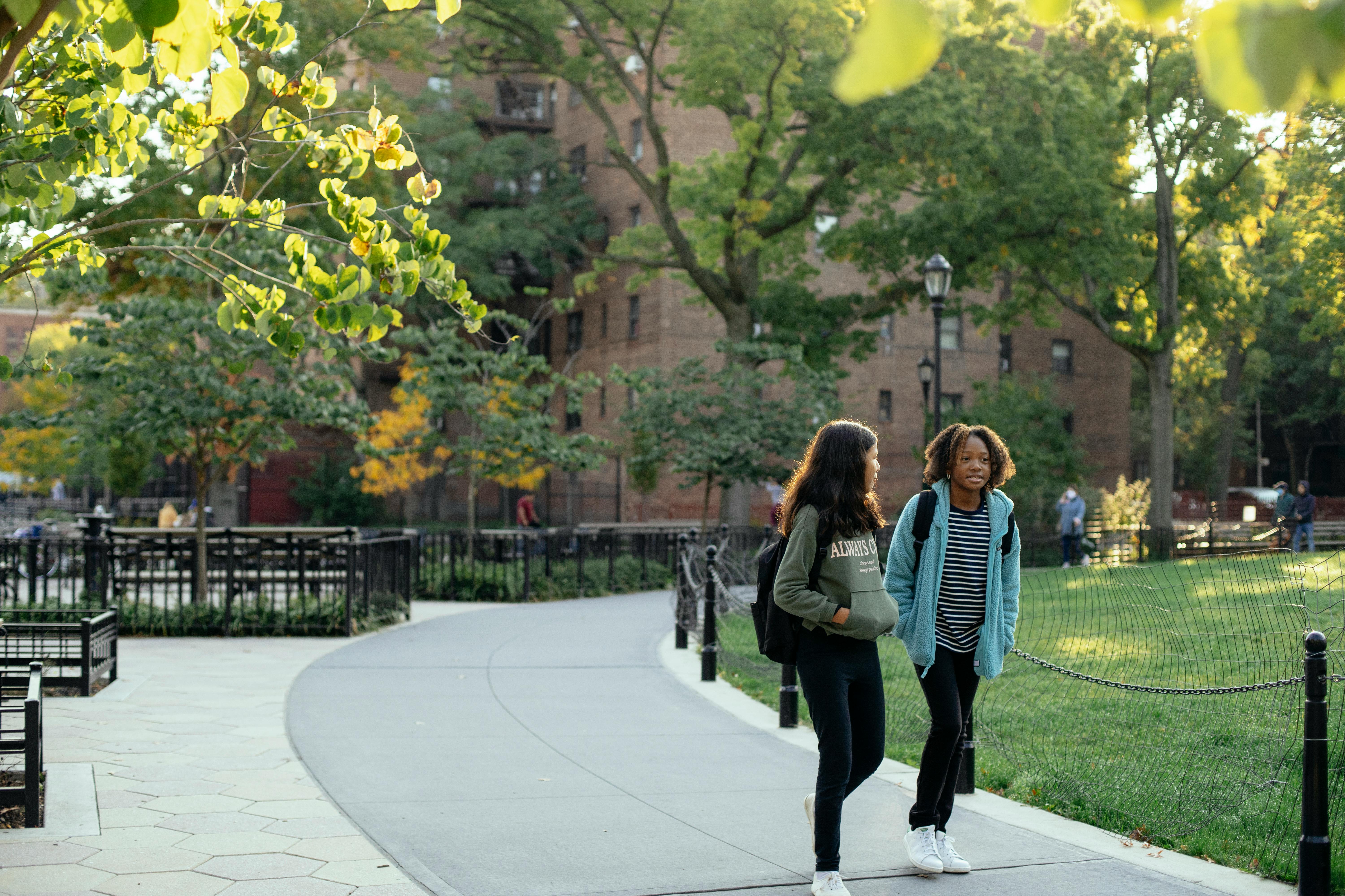 happy classmates walking in green summer park