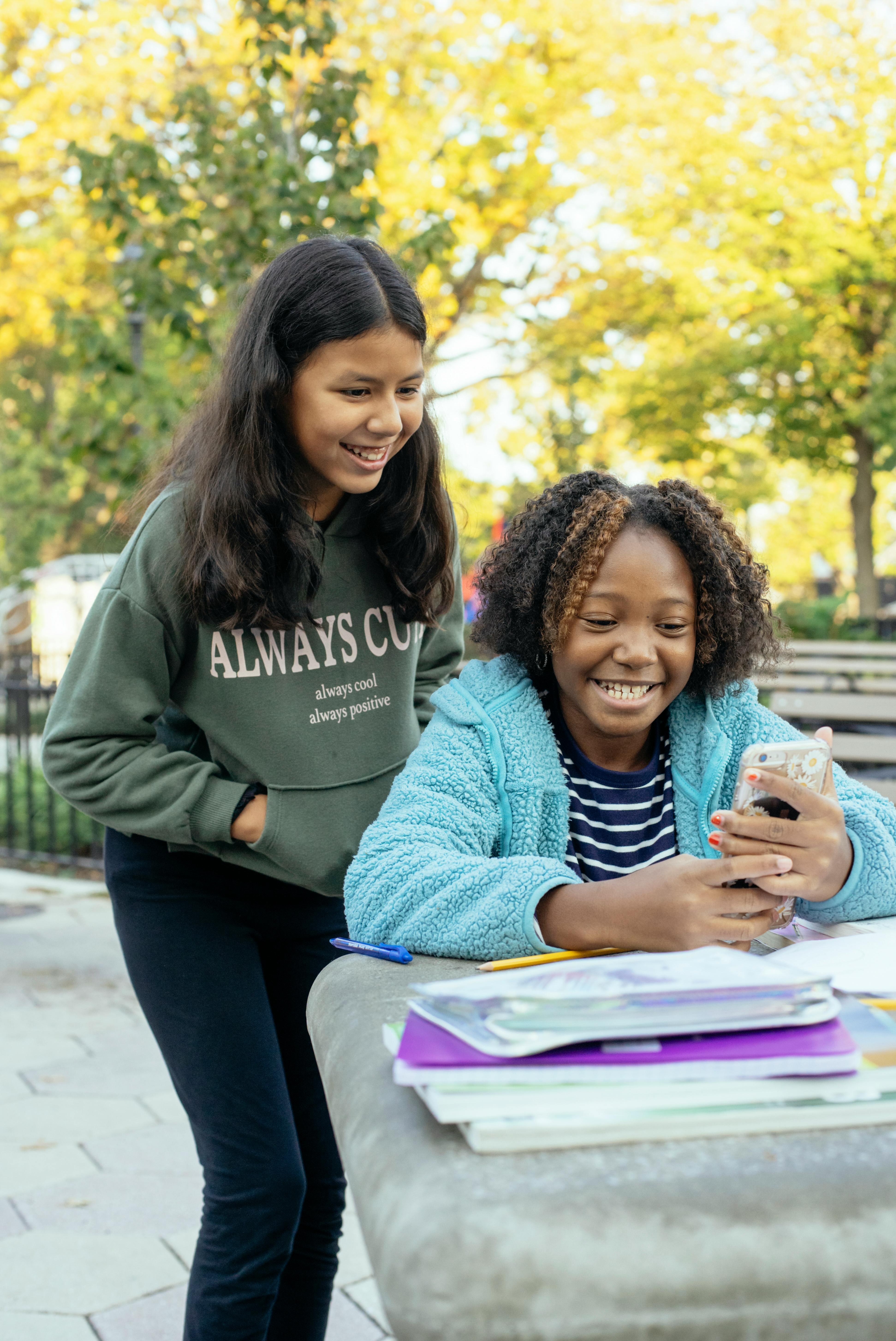 multiracial little girls browsing smartphone together