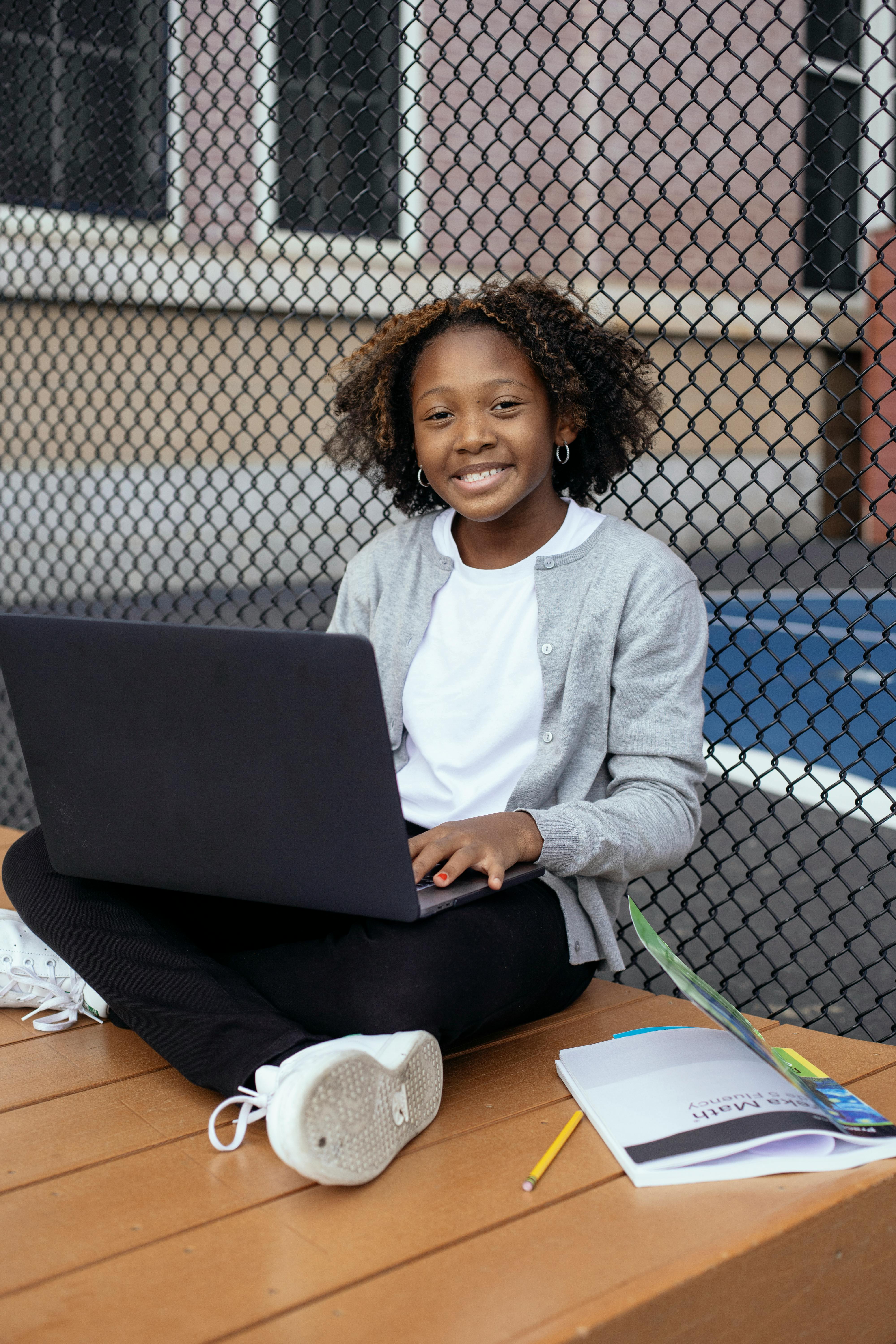 black student with laptop and textbook