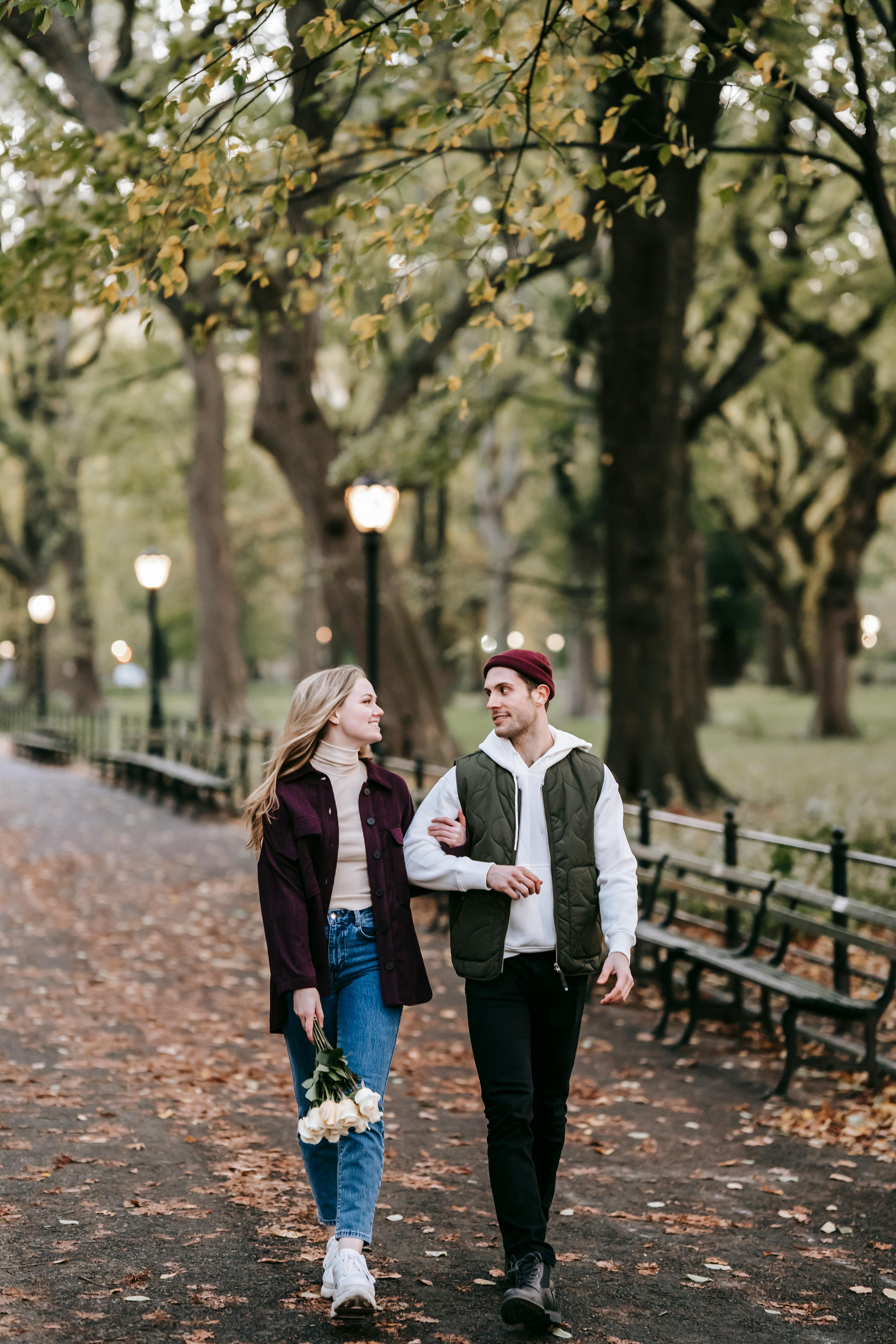 couple strolling with flowers in autumn in park