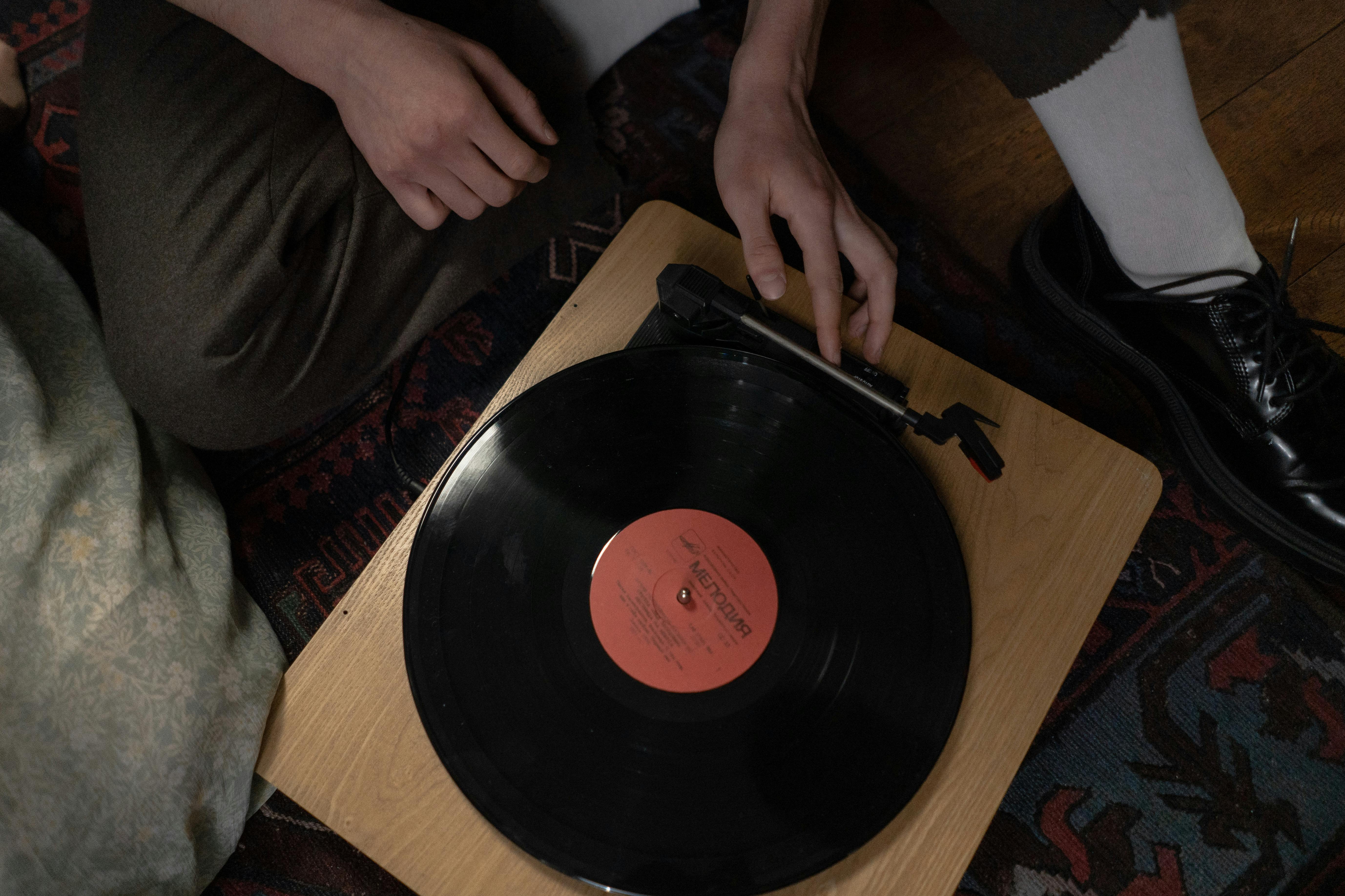 person holding a wooden phonograph player