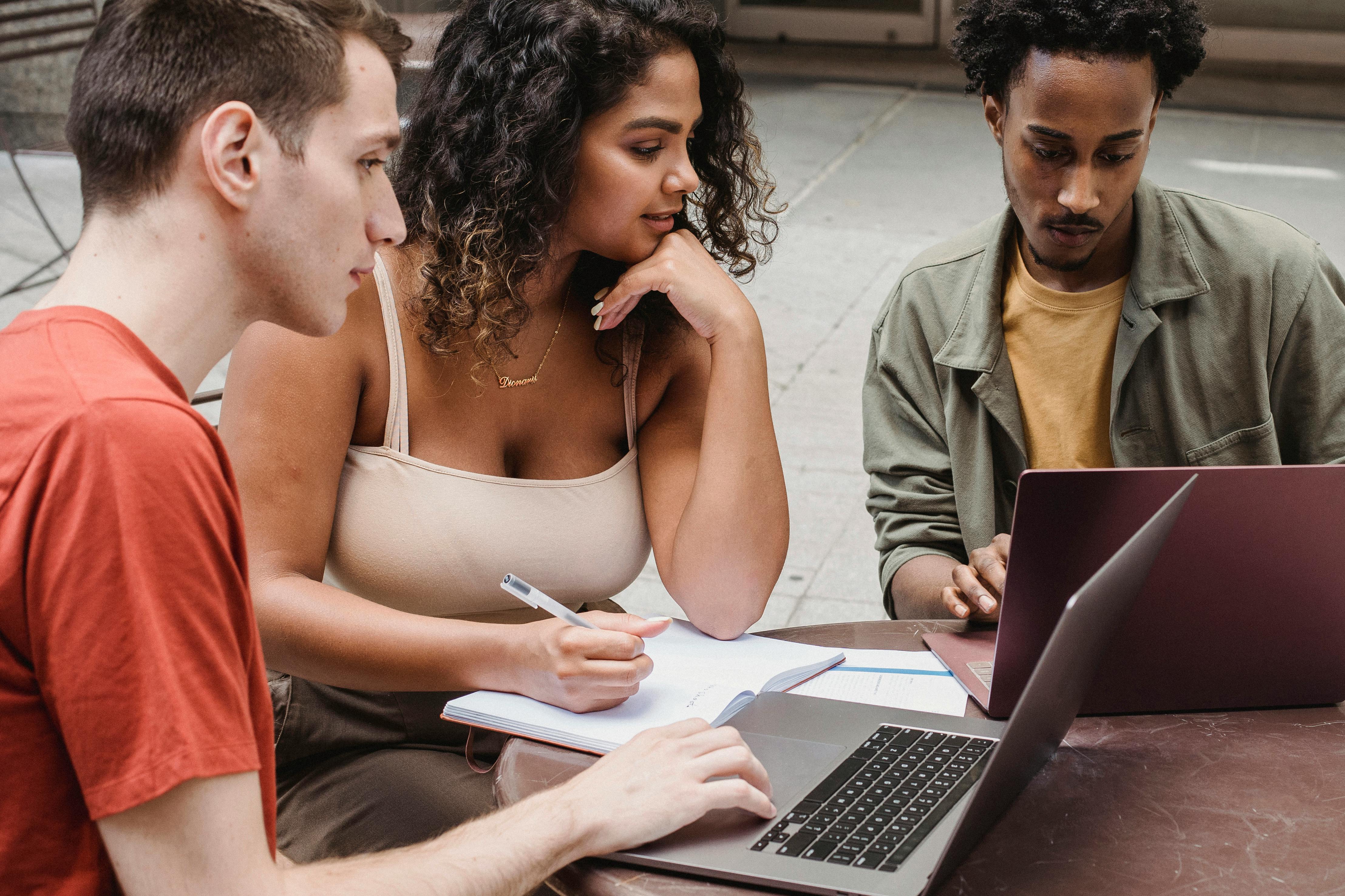 range focused diverse students preparing for exams victimization netbooks on street