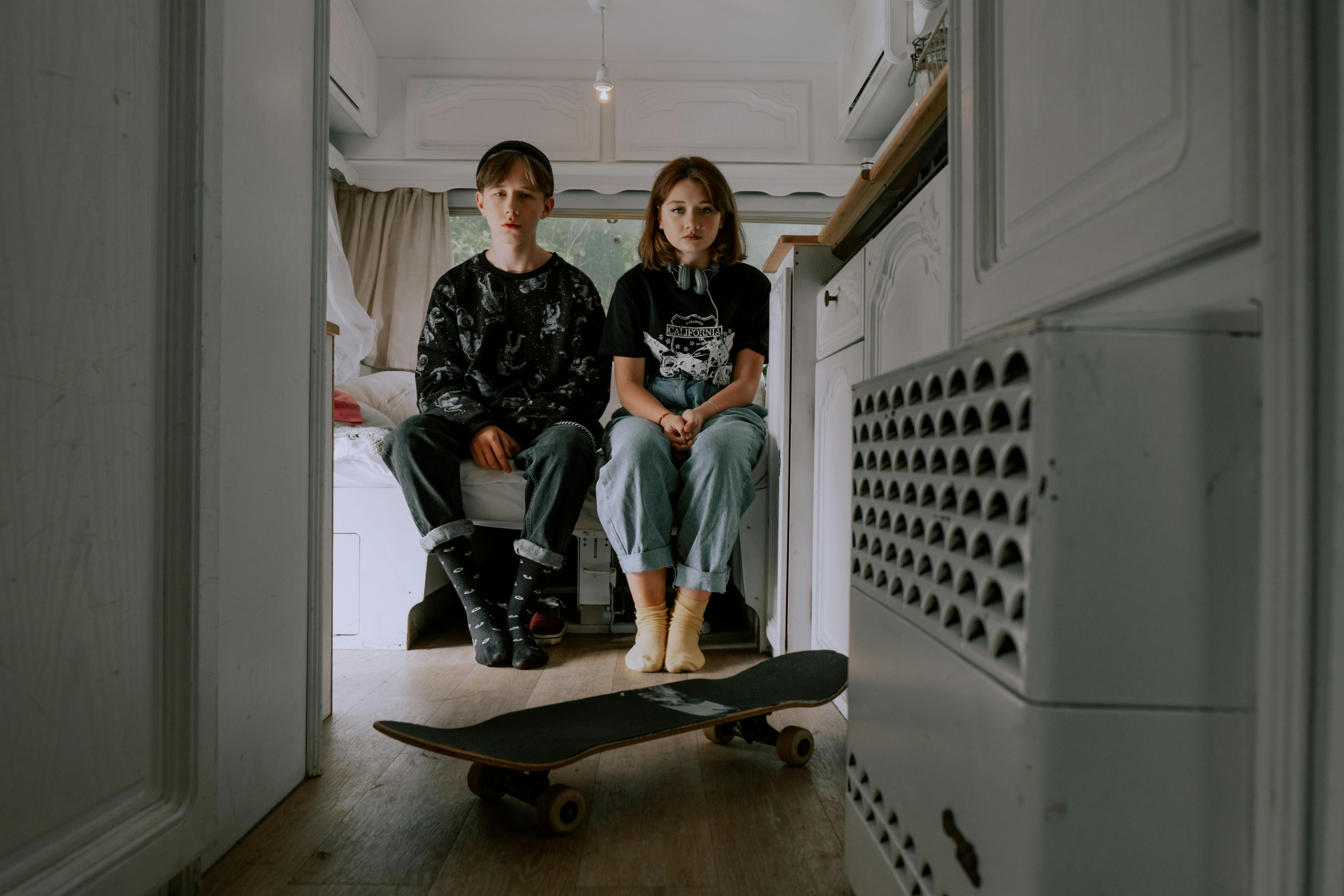 a teenager boy and girl sitting inside a room