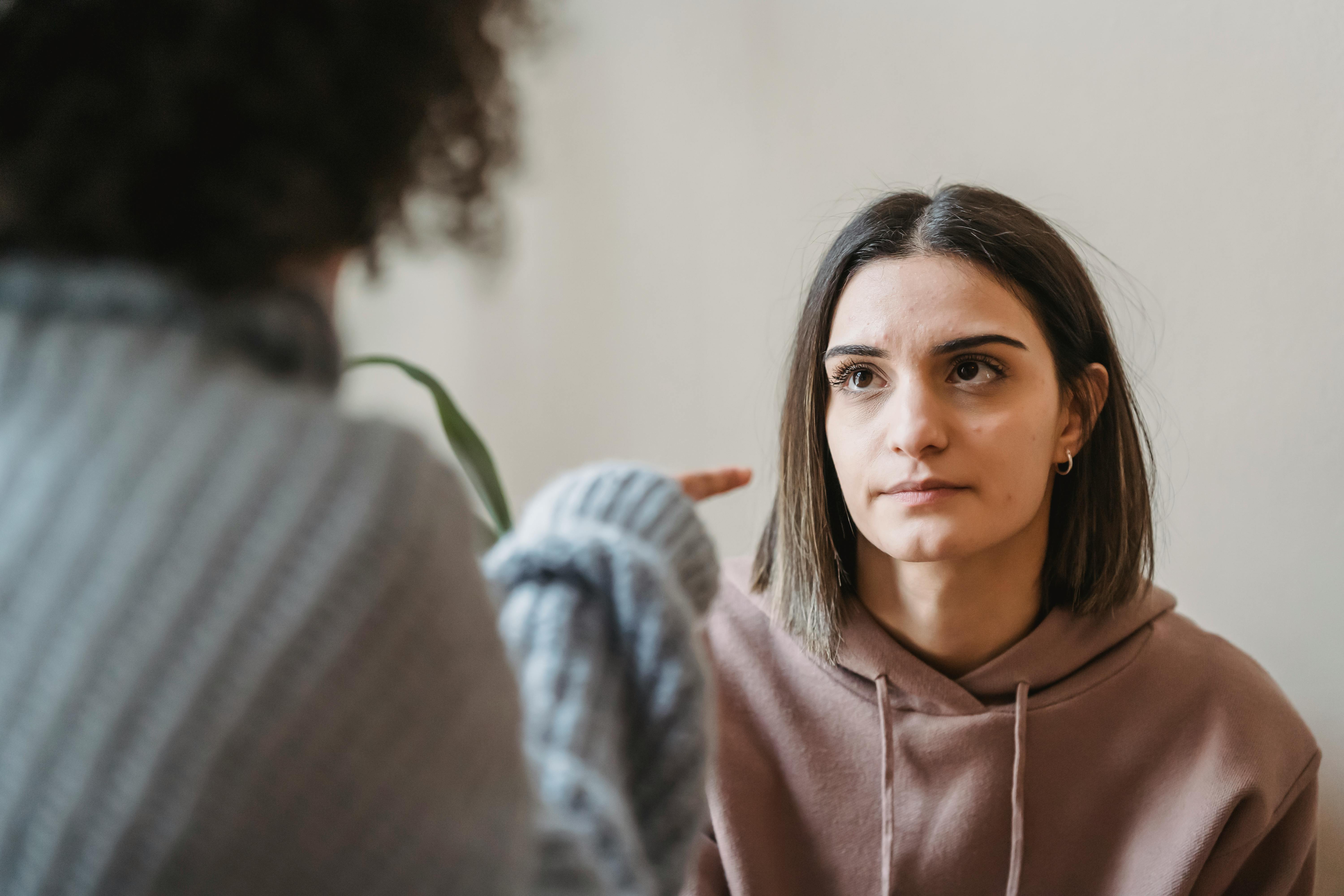 women arguing while pointing finger in face at home