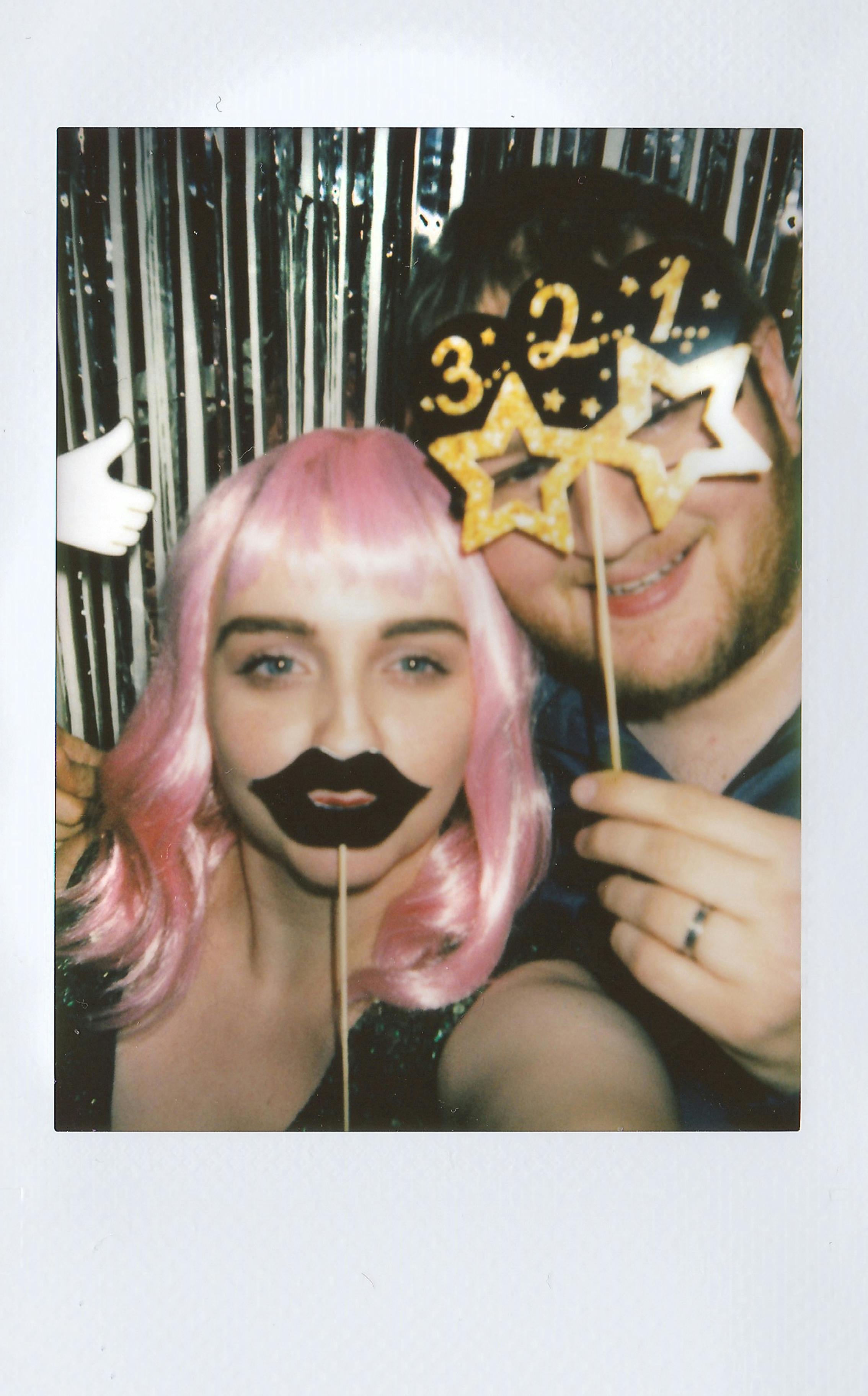 polaroid photo of a man and a woman holding cutouts