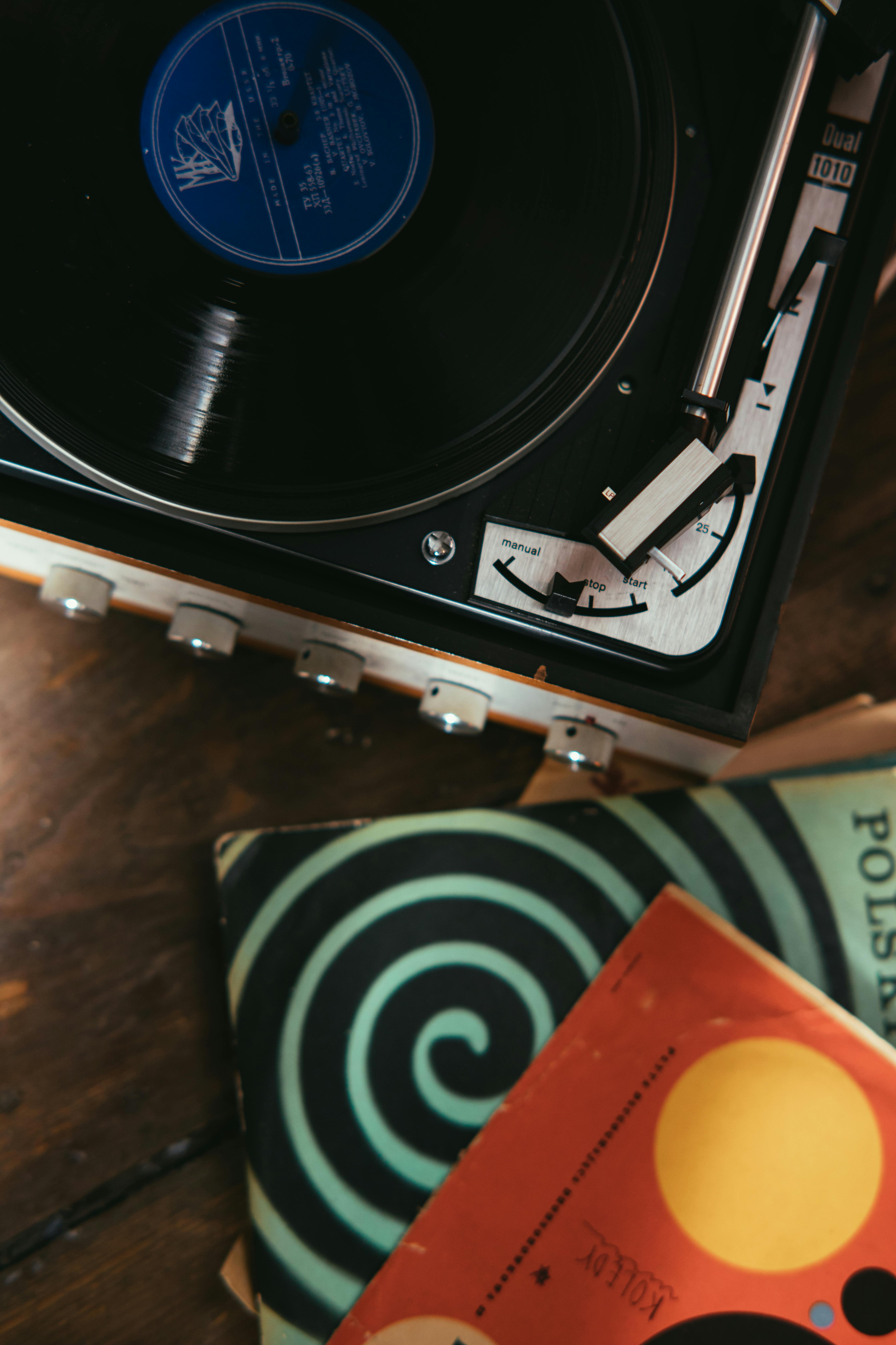 stacked vinyl records beside vinyl player